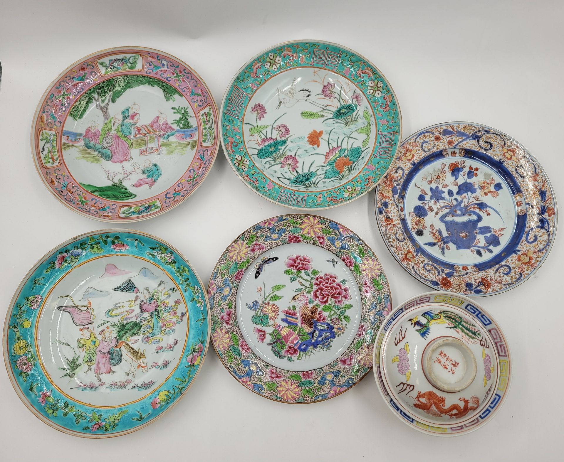 Lot de 4 assiettes et 1 bol couvert en porcelaine, Chine, XXe 
- Assiettes à décor polychrome de paysages animés pour 3, dans le style famille rose compagnie des Indes pour 1. 
- Bol à décor de phénix et de dragon. Hauteur : 10 cm 
On joint une assiette Imari XVIIIe