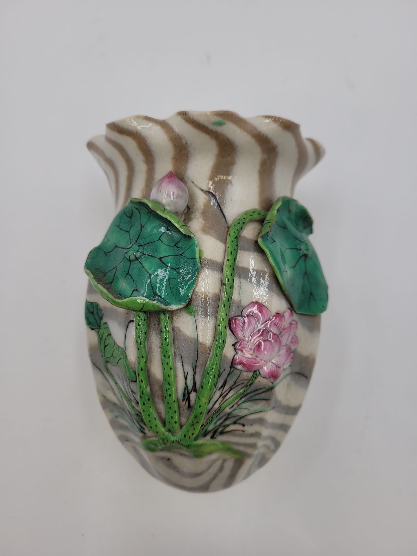 Porcelain Hanaike, Banko, Japan, late Meiji period 
Forming an applique, with polychrome decoration in relief of water lilies on a marbled background. Bears the mark on the back. 
Height : 12,2 cm 
Small lack on a water lily leaf.