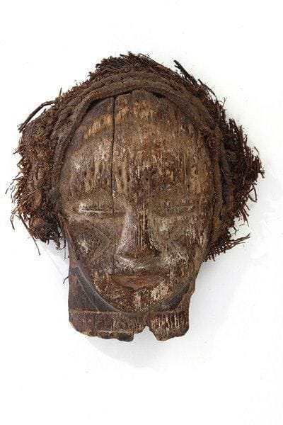 Masque diminutif FANG (Gabon). Belle patine brune brillante, coiffe de cordelettes. H : 16,5 cm.