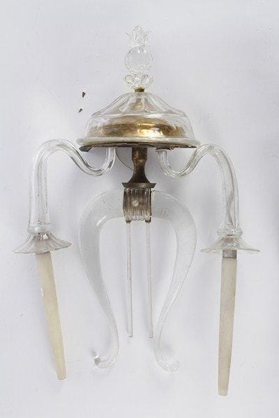 Suite de quatre appliques à deux lumières en verre blanc, le motif central en forme de lyre,  le cul-de-lampe nervuré se terminant par une graine à feuillage. XXe siècle. H : 61 cm - L : 40 cm.