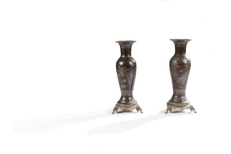 Paire de vases en céramique, genre Chine, à fond cuir, à décor circulaire de phénix dans des nuées, encadrés de dessins géométriques. Ils reposent sur des bases à piétement tripode à têtes d'éléphant. Les côtés ajourés. Vers 1860-1880. Légères restaurations. H : 57 cm - D : 17 cm.