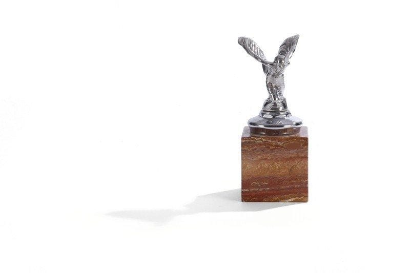 Charles Robinson SYKES
Spirit of Ecstasy ou Flying Lady. Modèle 1934 (modèle agenouillé). Bouchon de radiateur argenté pour Rolls Royce sur socle marbre. H : 20 cm.