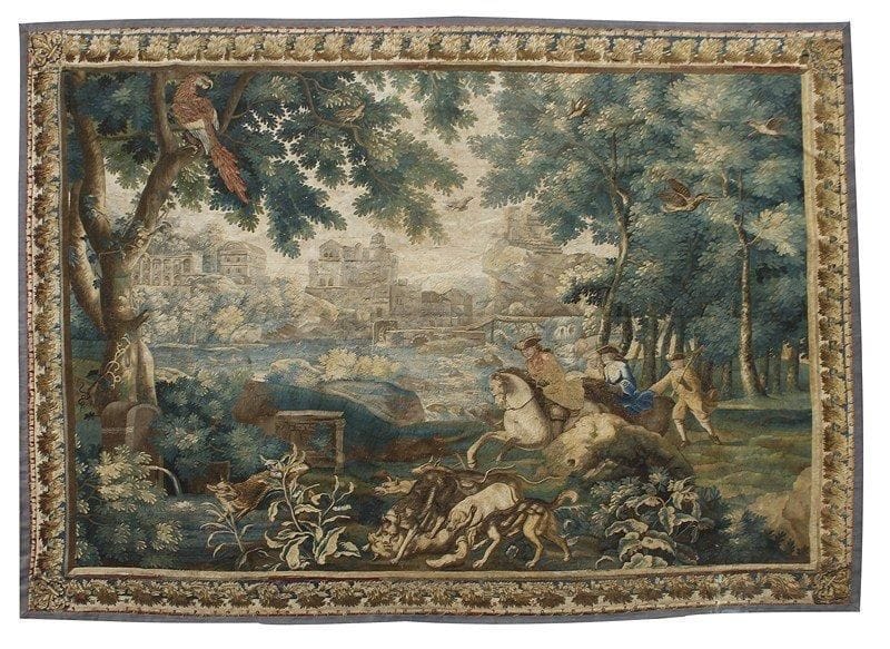 Tapisserie de Beauvais du XVIIIe siècle  Très fine tapisserie à décor de cavaliers chassant des renards sur un fond de rivières et de châteaux entourés d'une forêt où l'on peut voir de nombreux volatiles haut perchés. Bordure dite «à cadre». 270 x 339 cm. Légères usures et quelques accidents. Légèrement rentreillée