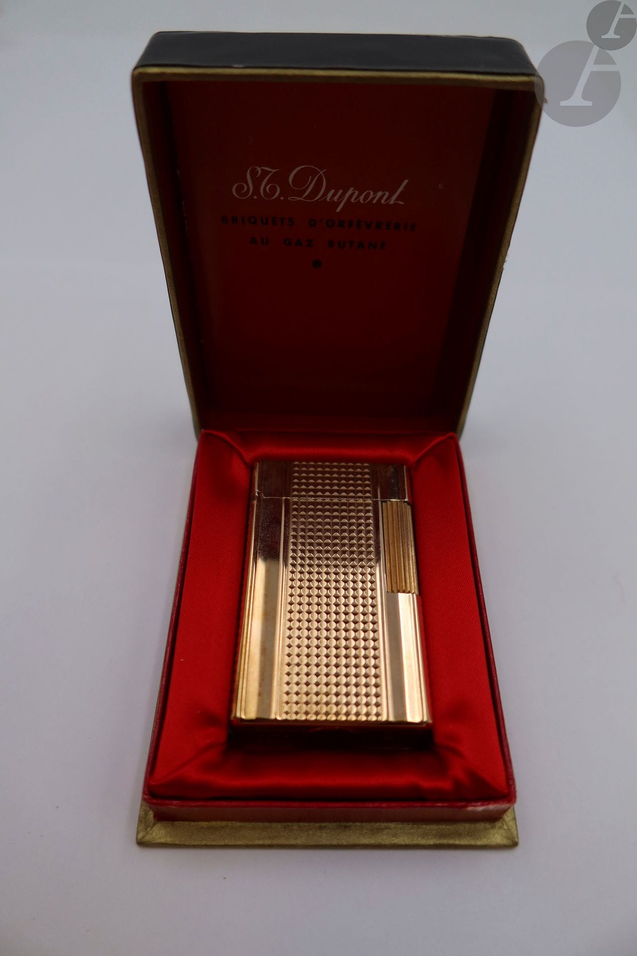 Briquet Dupont en métal doré, dans son étui. 

Poids brut: 93,9 g