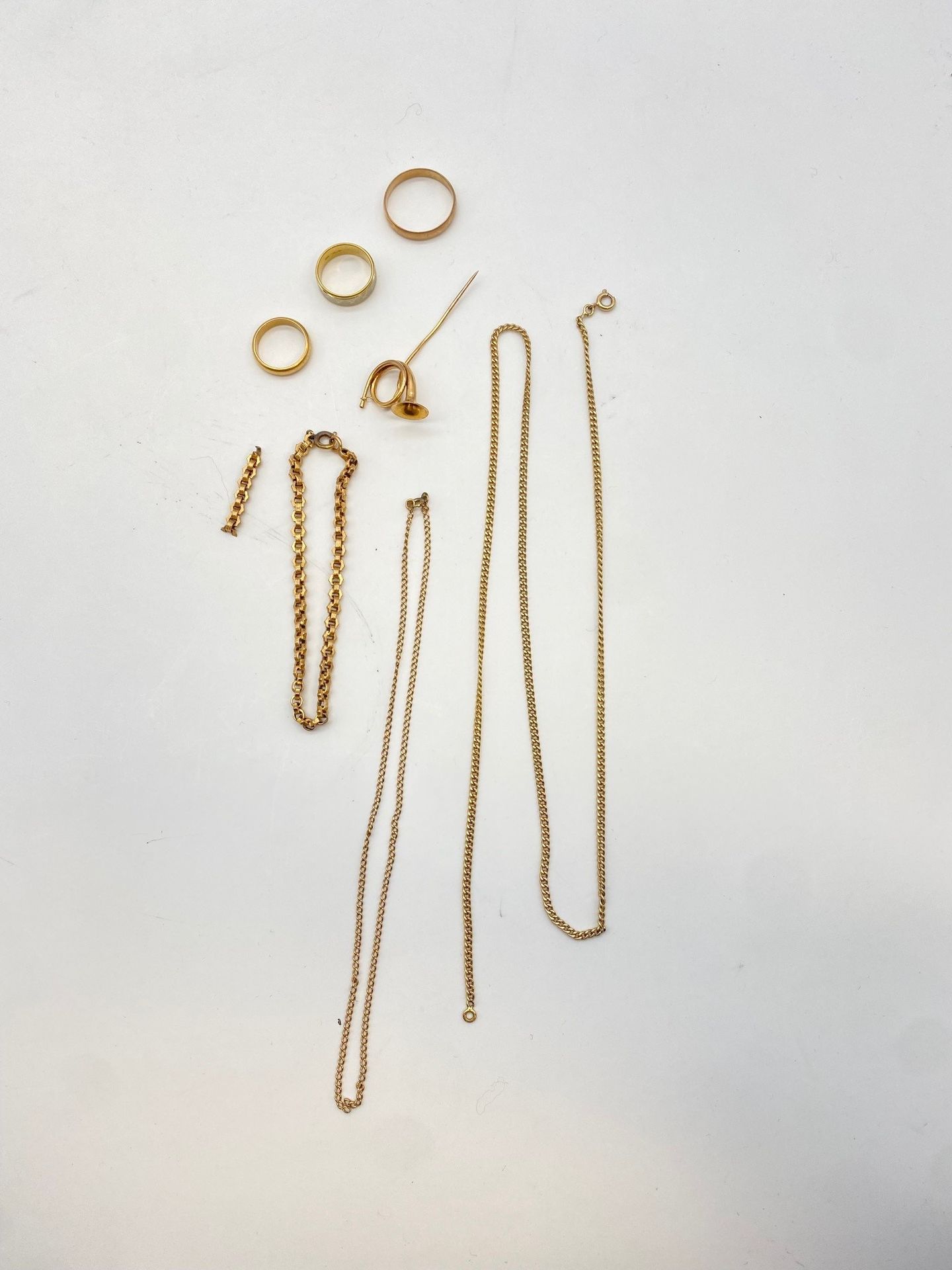 Lot de bijoux en or (18K et 14K). Poids brut: 34,5 g

- 3 alliances, un bracelet souple, une épingle cor de chasse et bris, en or (18K). Poids brut: 26,6 g

- une chaine en or (14K). Poids: 7,9 g