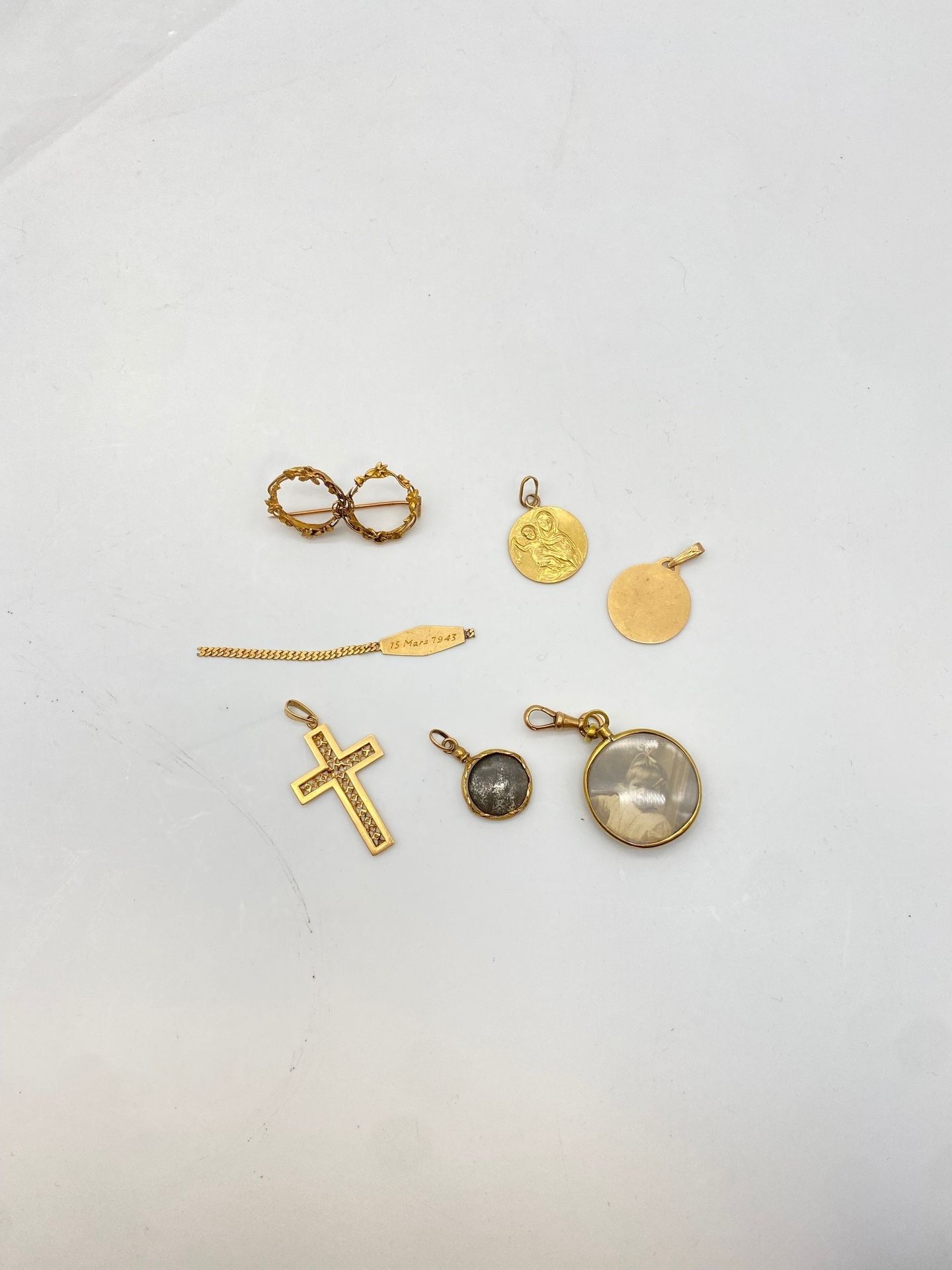 Lot de bijoux en or (18K). Poids: 11,7 g 

(2 médailles religieuses, un pendentif croix, 3 pendentifs cadres et bris).