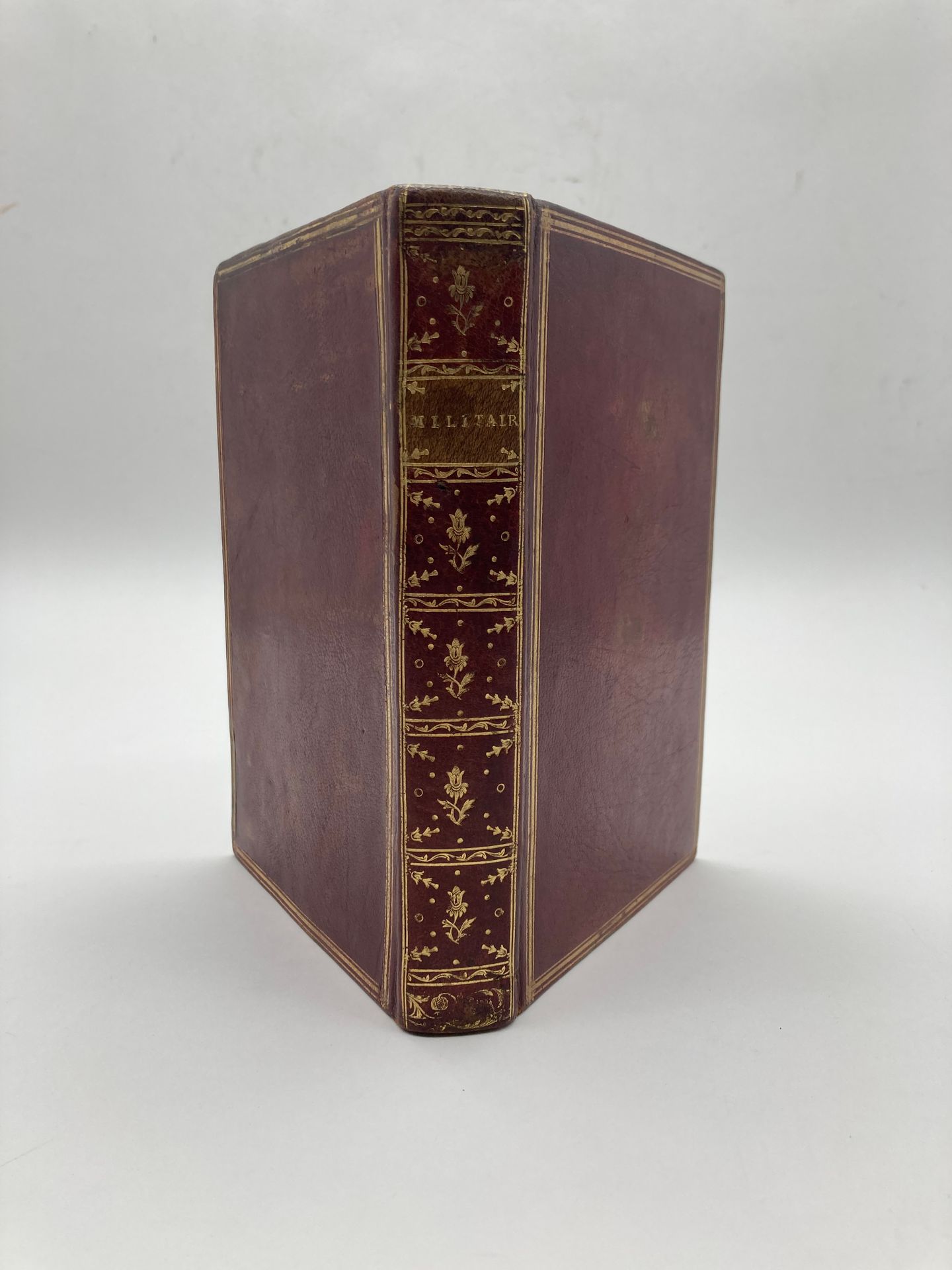 *MILITARY STATE OF FRANCE 
[at title: Military; first engraved vignette with mention: "Extrait de l'Etat du militaire de France 1777"].
In French, manuscript on paper; divisions with engraved vignettes. France, 18th century (after 1777). [7] unch. ff. + 274 pp. followed by [4] ff. blank, complete manuscript, fine calligraphic writing in ink, various parts introduced by engraved vignettes instructed in ink, the rest of the leaves entirely handwritten. Bound in full red morocco, smooth spine cloisonné and fleuronné, title-piece "Militair[e]", triple gilt fillet framing on the more, with thicker middle fillet, gilt fillet on the edges, inner scroll, blue tabis endpapers, gilt edges (boards a little rubbed, freckles to the paper in places). 
Dimensions : 20 x 13 cm

Provenance: 
- Engraved ex-libris vignette of Jean Gigodot, pasted on the upper back cover. 
- Ex-libris vignette of Charles Van der Elst (1904-1982), president of the Royal Society of Bibliophiles and Iconophiles of Belgium, pasted on the verso of the first guard.


ATTENTION: This lot is subject to the temporary import tax of 5,5%.
