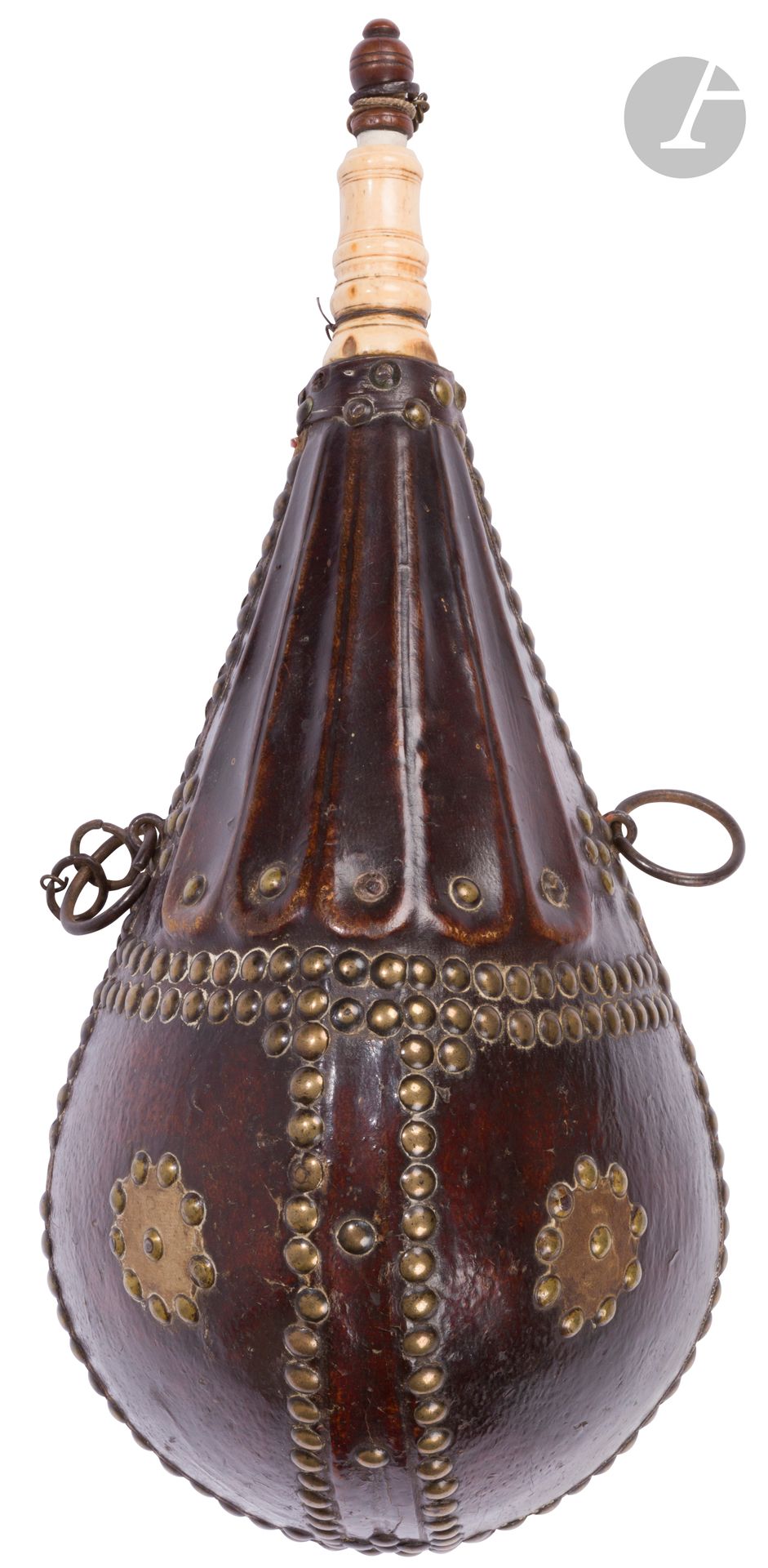 Grande poire à poudre en bois, à deux anneaux de suspente, recouverte de cuir, à décor clouté et rosaces en laiton. Bec en bois de cerf. Bouchon en bois.
B.E. XVIIIe siècle.
39 x 17,5 cm