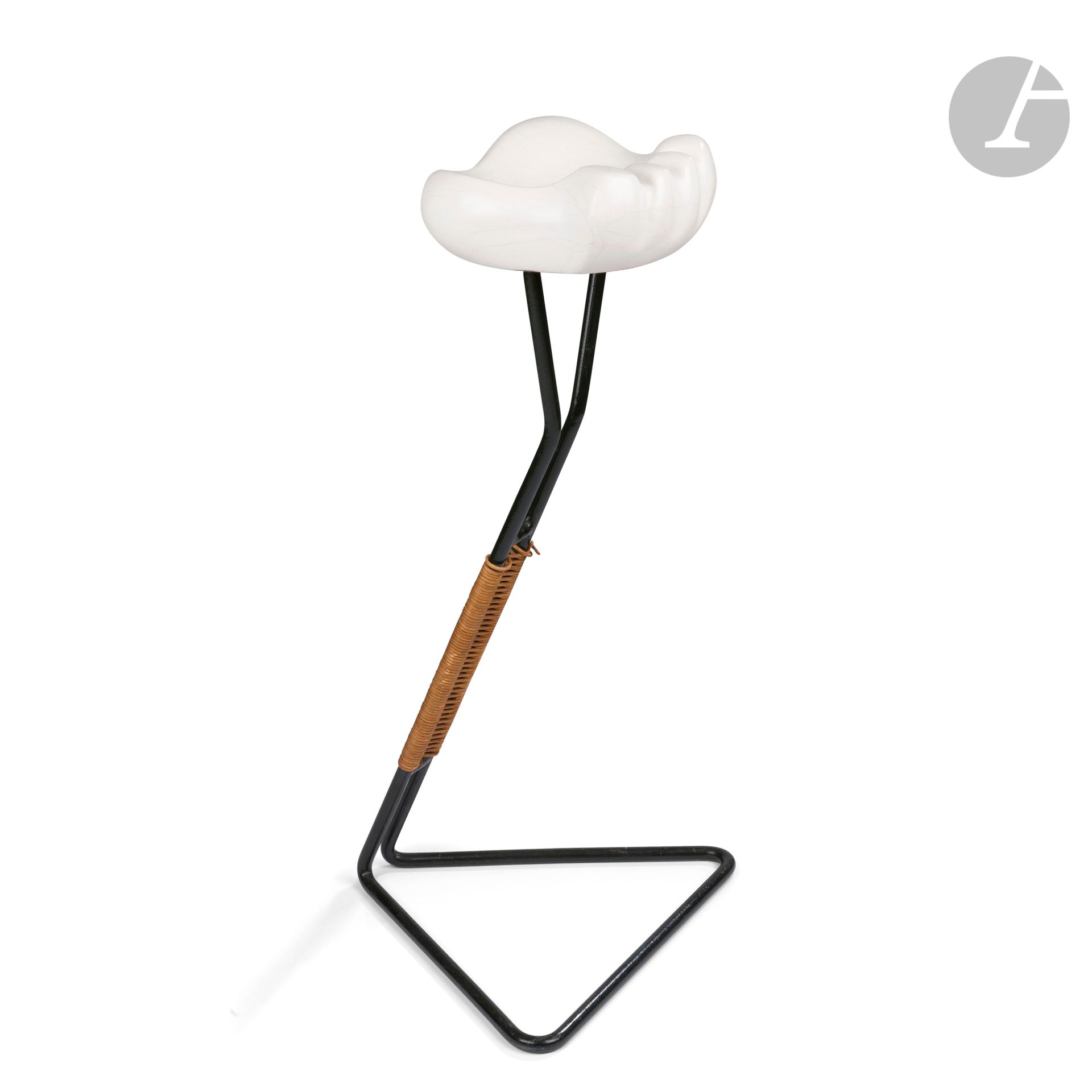 GEORGES JOUVE (1910-1964) CÉRAMISTE & MATHIEU MATÉGOT (1910-2001) DESIGNER
Cendrier sur pied (pied fumeur), modèle créé vers [1951]
Le pied à base triangulée en métal laqué vert ; la préhension clissée de rotin. Le cendrier à l’évocation d’une Patte d’ours. Épreuve en céramique émaillée blanc à la résille de très fines craquelures grises. Années 1950. Une légère restauration à la surface de l’émail au fond, un saut d’émail comblé sur une arête. Le cendrier monogrammé A. P. (pour Apollon) dit à l’Alpha au revers. H. pied seul : 56,5 cm - H. totale : 63 cm – Cendrier : H. 7,5 cm – L. 18 cm – L. 18 cm

Bibliographie :
- Préface de Pierre Bergé, textes de Philippe Jousse et de Norbert Pierlot – Georges Jouve – Éditions Jousse Entreprise, Paris, 2005. Variante de couleur reproduite page 167.
- Collectif – Mathieu Matégot – Éditions Jousse Entreprise, Paris, 2003. Variante de couleur reproduite page 89.
