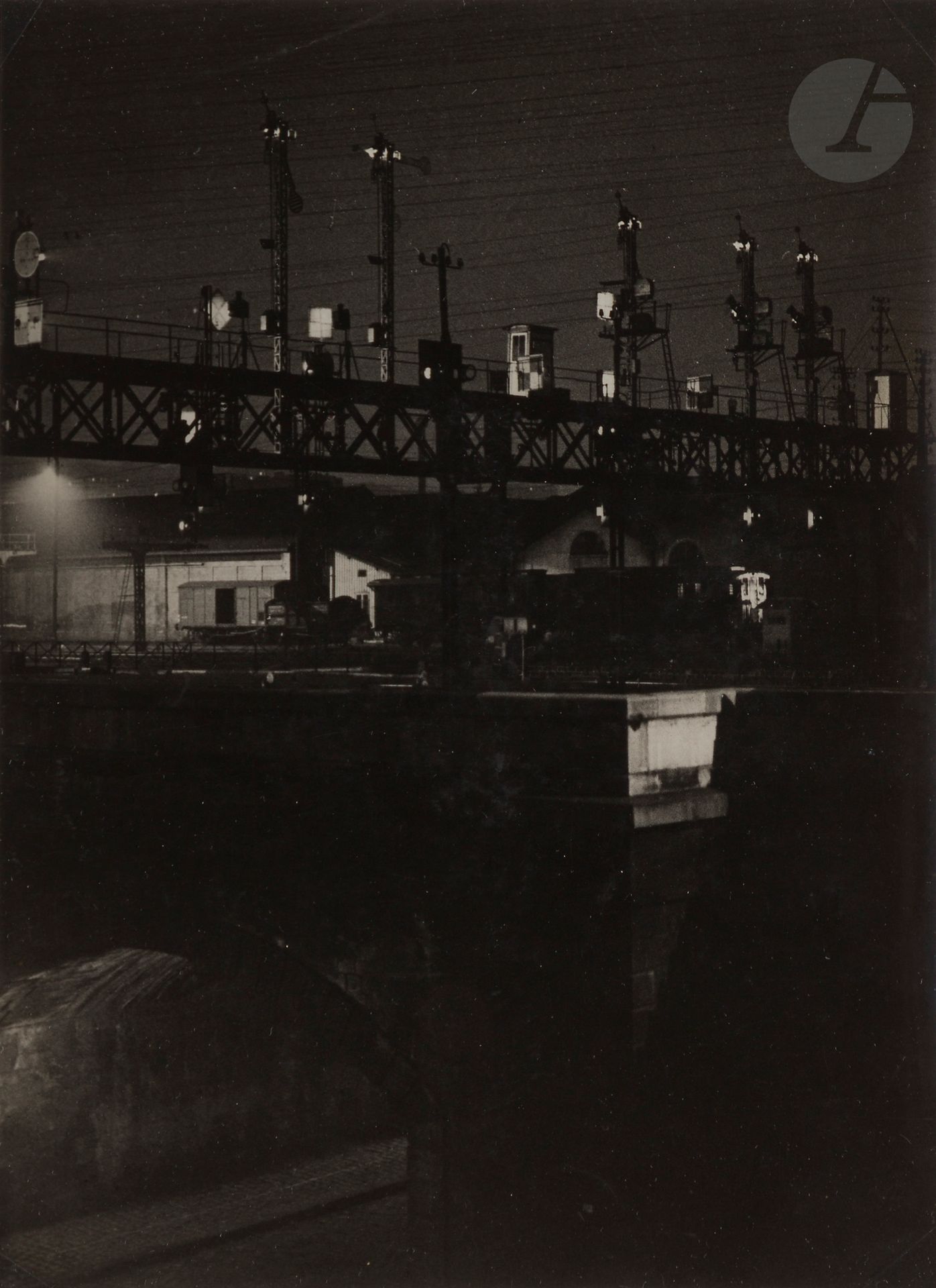 Brassaï (Gyula Halász, dit) (1899-1984)
Canal de l’Ourcq de nuit. Paris, 1932. 
Épreuve argentique d’époque. Tampon « Photo Brassaï - Copyright by Gyula Halász - 74, rue de la Glacière - Paris (13e) » et annotations manuscrites au verso. 
23,5 x 17,5 cm - cadre