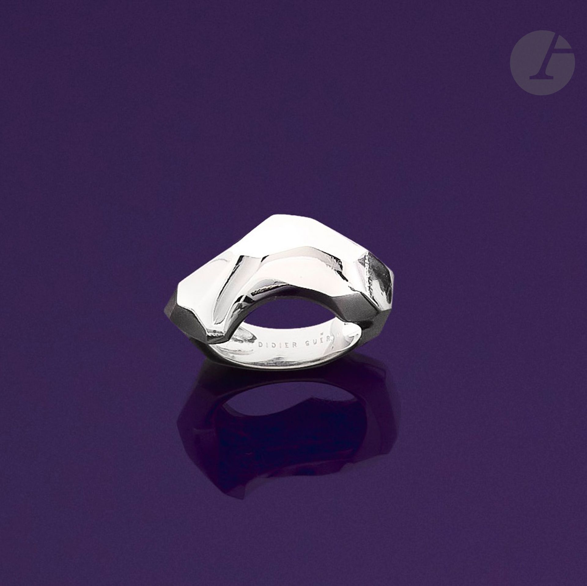 DIDIER GUERIN
Large bague en or gris 18K (750) asymétrique, facettée. Signée. Travail français. Tour de doigt : 52/53. Poids brut : 14,6 g

A Didier Guerin ring