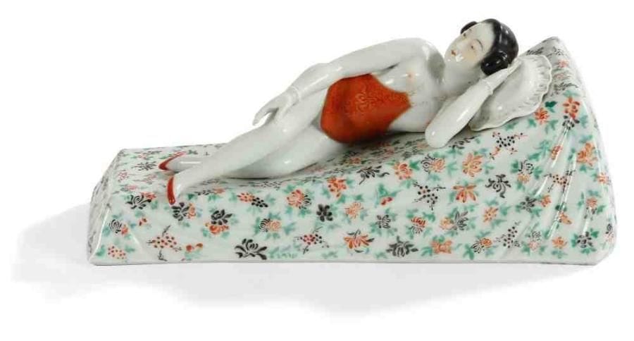 Personnage en porcelaine polychrome représentant une femme dénudée se prélassant sur un lit orné de fleurs. Cachet au-dessous Wei Hongtai Zhao. (Petits manques sous le socle). Shangai, vers 1920. Dim. : 9 x 20,5 cm