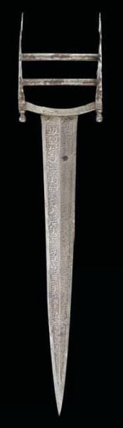 GRAND POIGNARD KATAR, INDE, DECCAN, XVIIIE SIÈCLE Lame en acier entièrement ciselée d'inscriptions religieuses sur fond de rinceaux disposées dans des cartouches. Poignée à deux passants aux branches fleuronnées en composition symétrique. (Un petit accident sur la lame) L.: 48,5 cm
