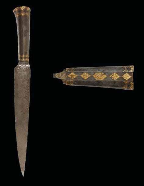 GRAND POIGNARD, KARD, IRAN, DATÉ 1253 H./1837 Lame droite en acier damassé ciselé au talon d'invocations religieuses en nasta'liq et petites rosettes disposées dans un demi-lambrequin. A la base du dos, petit médaillon inscrit au nom du propriétaire en damasquinage d'or donnant: «le propriétaire est Hâjjî Râgeb ?Alî». Poignée creuse à pans en acier également damassé et richement damasquinée d'or de fleurons dorés à la base de cannelures, et sur la soie, de cinq cartouches polylobés sur lesquels se détachent en réserve les noms des ahl al-bayt. (Manque le pommeau à l'extrémité de la poignée) L.: 42 cm Un poignard similaire daté 1221 H./1813 de l'ancienne collection Holstein a été publié dans son ouvrage Contribution a l'etude des Armes Orientales, t. II, Paris, 1913, n°18, p. 212