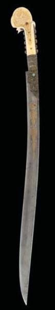 BEAU SABRE YATAGAN, BALKANS, SIGNÉ ET DATÉ 1225 H./ 1810 Lame en acier damassé, damasquinée d'or d'un cartouche inscrit de deux lignes donnant «a été fabriqué par Husayn [?] Son propriétaire est Ahmad [?] Bû Yahyâ ?Alî» suivi d'une invocation pour le propriétaire et de la date 1225 H./1810 disposée dans une demi-palmette lancéolée sur un côté et d'un cercle magique associé à une composition géométrique lancéolée de l'autre. Talon filigrané à décor de rinceaux et cabochons de turquoise. Monture en ivoire et soies ornées de cabochons de corail. L.: 72 cm
