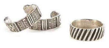 PAIRE DE CHEVILLIÈRES KHALKHAL ET BRACELET EN ARGENT, SUD DU MAROC, FIN XIXE SIÈCLE Chevillières à décor gravé de bandeaux verticaux géométriques et fermetures en boule aplatie et bracelet à décor de godrons torsadés et gravés. Diam.: 7,5 et 6,5 cm