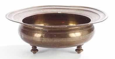 BASSIN EN LAITON, EMPIRE OTTOMAN, XIXE SIÈCLE Bassin tripode à panse bombée et large aile. Décor gravé d'une frise de palmettes sur l'aile, cordon tressé au rebord et ceinturant la panse. Sous la base, belle marque de propriétaire dans une mandorle à tige fleurie. (Marque de propriétaire grattée et petits chocs) Diam.: 34,5 et H.: 12,5 cm