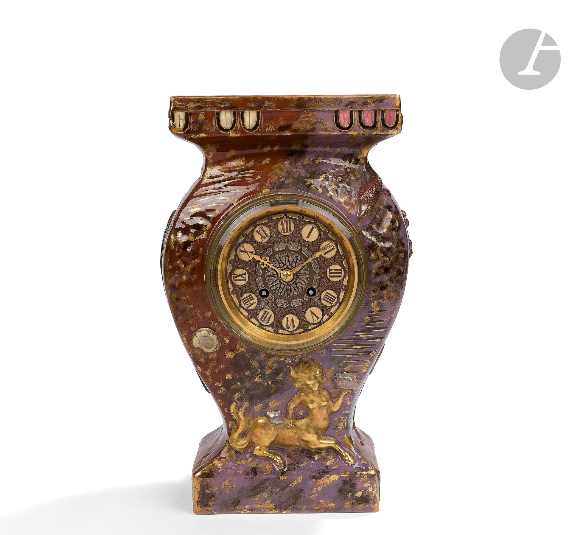 ÉMILE GALLÉ (1846-1904)
Centauress &amp; Woman riding a sea horse &amp; Aquatic flora and fauna
Very rare clock.
The centauress, the sea horse and the aquatic plant, evoking a caduceus, are entirely covered in kiln-fired gold.
The dial is in repoussé brass, patinated and, in part, polychromed, and features circular cartouches with Roman numerals.
Hands in Renaissance style.
Complete with its G. F.
Circa 1880.
Missing balance wheel, stamp and back cover.
Signed E. GALLÉ Nancy - E. G. (à la Croix de Lorraine) Déposé and bears an old label with handwritten ink under the base.
Height: 31 cm - Length: 19 cm - Depth: 14 cm