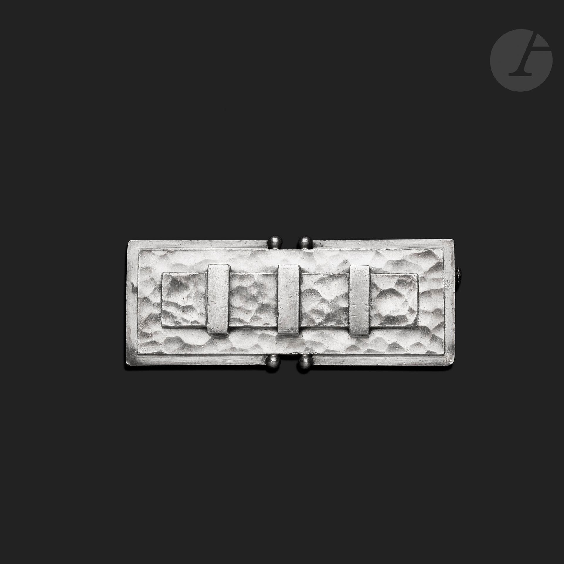 JEAN DESPRÉS (1889-1980)
Rare modernist silver brooch.
The large rectangular base, with two central indentations adorned with small spheres, receives a slightly raised, entirely hammered plate, housing the decoration of a wide barrette held in place by three smooth treated clasps.
Signed J. DESPRÉS at the point on the back and bearing the Master Goldsmith and guarantee marks on the reverse.
Weight : 30 g

Provenance :
- Former Mr. and Mrs. P. Collection (Avallon - France), acquired by them directly from the artist.
- Arts Décoratifs et Sculptures du XXe siècle - Vente Ader, 2 juin 2017. Lot N° 91 of the catalog.
- Work acquired at the previous auction by the current owner.