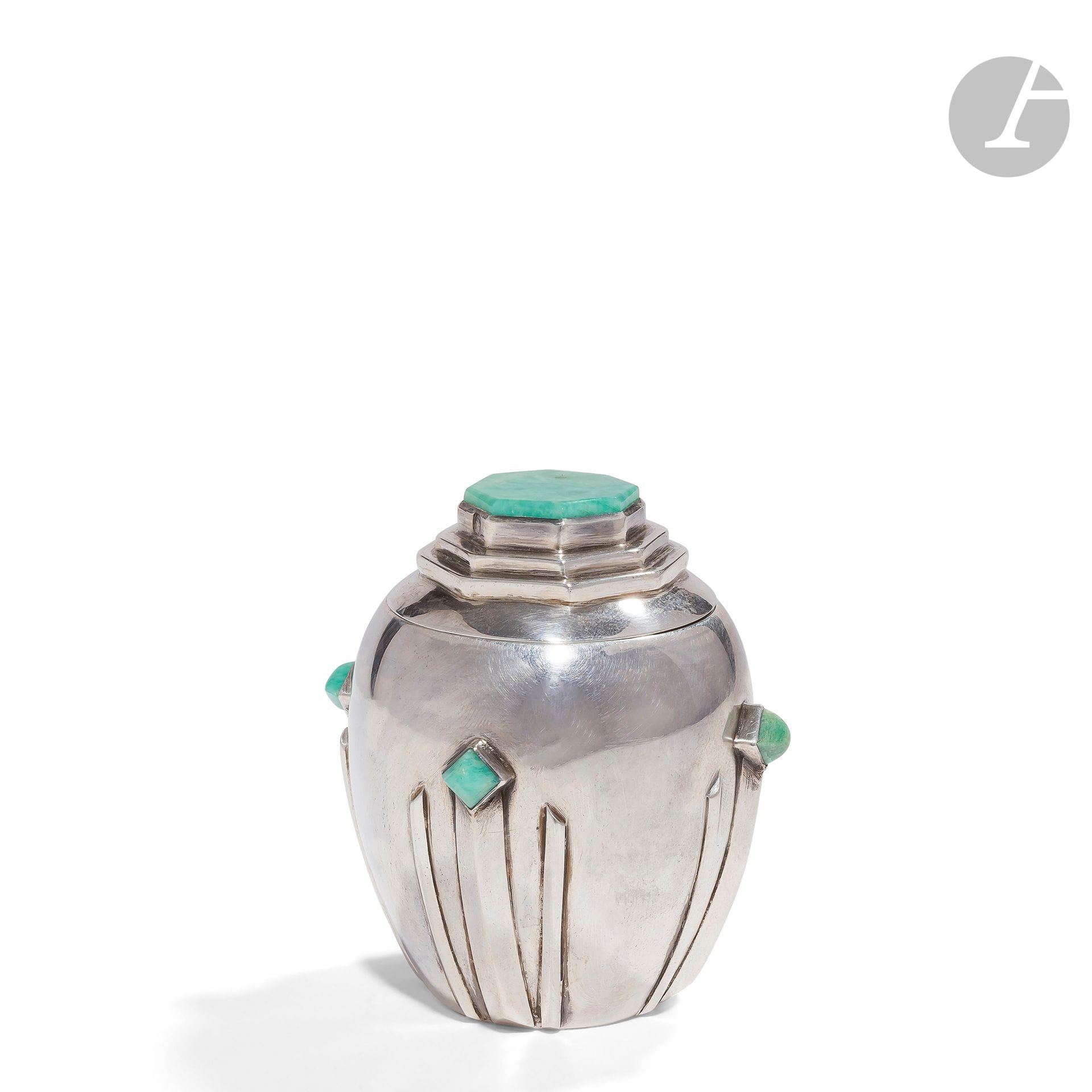 FERNAND GRANGE - ACTIF DU 16 AVRIL 1909 AU 8 FÉVRIER 1961
Rare et précieux pot couvert en argent et amazonite.
La base aux motifs en ressaut de joncs triangulaires et accueillant des cabochons en amazonite.
Le couvercle, bombé et aux gradins hexagonaux, sommé d’un gros cabochon également en amazonite.
Vers 1925.
Édition La Gerbe d’Or.
Signé du cachet F. GRANGE et porte les poinçons de Maître Orfèvre sous la base et de garantie sur le couvercle.
Hauteur : 6,5 cm
Poids brut : 76,23 g