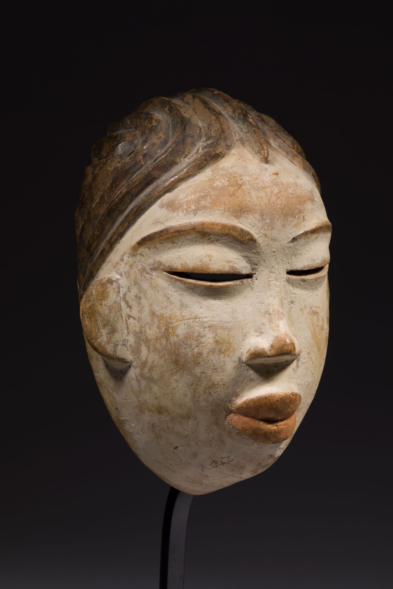 A mask of rejoicing with large slit eyes, a generous and serene face, white polychromy and pink lips. Although white represents death, in relation to the moon, it also represents positive feminine qualities such as goodness, peace, purity, beauty and reproductive vigor. Benjabi, Gabon

Wood, pigments, patina of use.

H. 27.5 cm



Provenance :

Jacques Viault Collection.