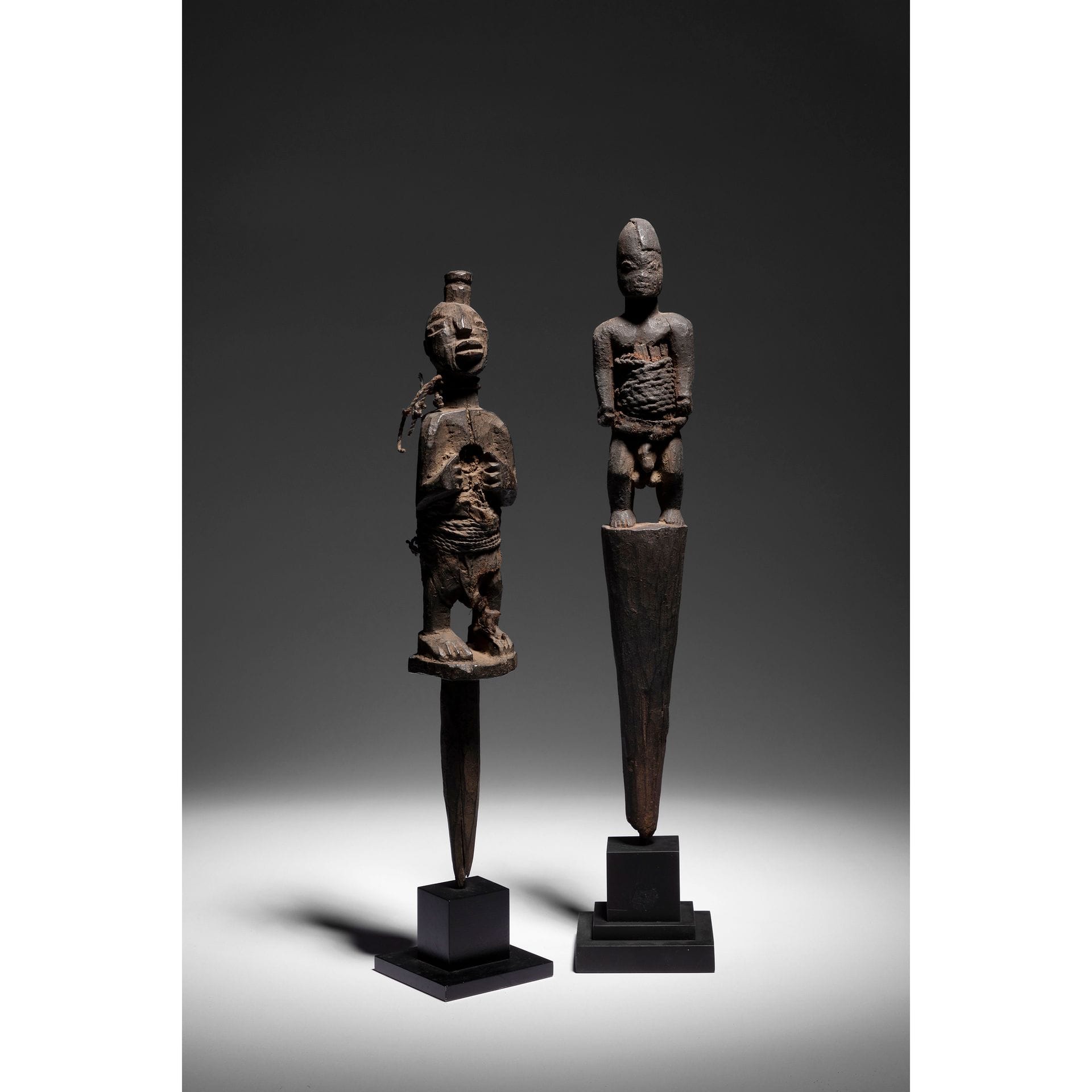 A group of two very old male voodoo stakes statuettes of bewitchment and control sculpted in feet, both bound with fabric additions and wooden plates, but with free arms, one of which has a shaved hair cut on one side and the other with important cleats in the chest to control the breath, thus life, or even provoke death, and another cleat in the skull to control the strength and will.

Nago and Fon, Benin

Wood, rope, cloth, clay, very beautiful and old patina.

H. 34 and 33 cm



Provenance :

Anne and Jacques Kerchache Collection.



Exhibition :

Voodoo Exhibition, Paris, Fondation Cartier pour l'Art Contemporain, 2011, exhibited but not reproduced in the catalog.