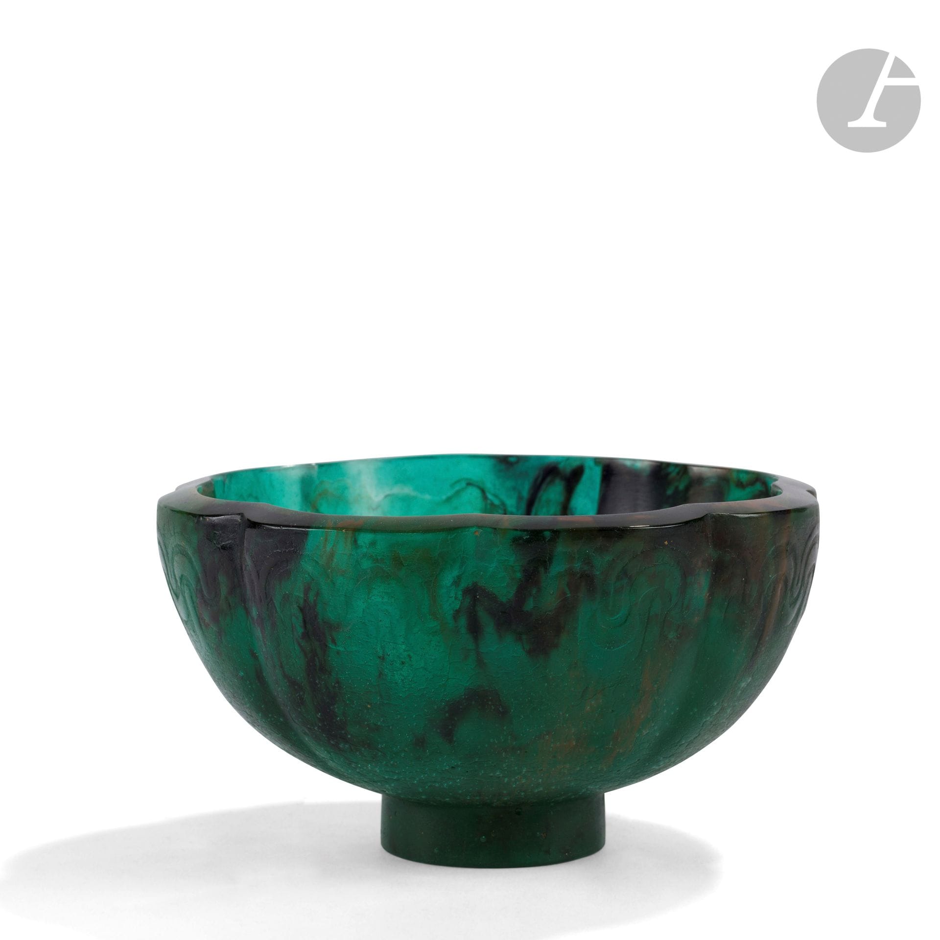 FRANÇOIS ÉMILE DÉCORCHEMONT (1880-1971)
Bol à côtes frise, le modèle créé en [1927], diffusé jusqu’en [1928], réputé avoir été édité à 17 exemplaires
Coupe à côtes de melon et reposant sur talon légèrement tronconique. Épreuve en pâte de verre émeraude aux traînées noires et ocre. Un défaut d’origine ou un éclat rodé en pourtour de la base. Marquée du cachet de l’artiste vers la base et de la mention A 884 gravée sous la base. H. 9,5 cm - D. 17,5 cm

Bibliographie : 
Véronique Ayroles – François Décorchemont, Maître de la pâte de verre – Éditions Norma, Paris, 2006. Modèle référencé sous le n° 322 ; notre œuvre reproduite page 141.
