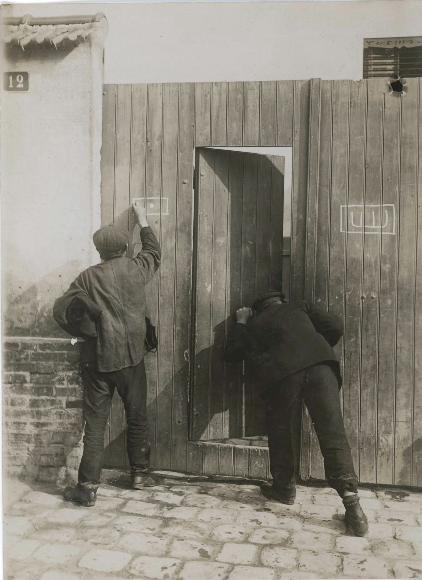 Charles Delius (1877-1962)
Cambrioleur appliquant des signes de repérage sur les portes, c. 1920.
Cinq épreuves argentiques d'époque. Tampon du photographe et légende tapuscrite sur étiquette (1) aux versos.
Formats : 11 x 15 et 13 x 18 cm