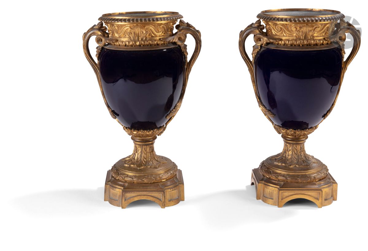 Paire de vases en porcelaine bleu à monture de bronze doré à frise de postes et piédouche feuillagé ; (sans couvercle).
Style Louis XVI, XIXe siècle.
H : 30 cm