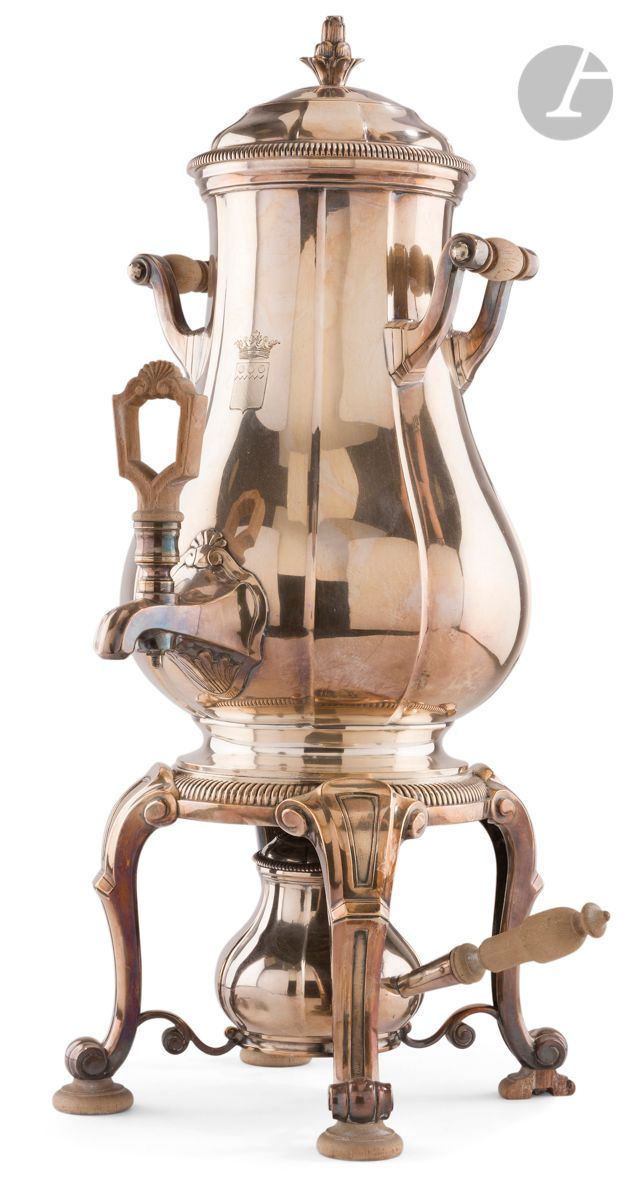 ÉMILE PUIFORCAT XXe SIÈCLE
Fontaine à eau chaude en métal complète de son brûleur, gravée d’une armoirie sur le corps de chauffe sommée d’une couronne de marquis. Modèle à pans quadripode, rehaussé de godrons, sommée d’une prise fleuronnée.
H : 42,5 cm
État : un des pieds circulaires en bois cassé