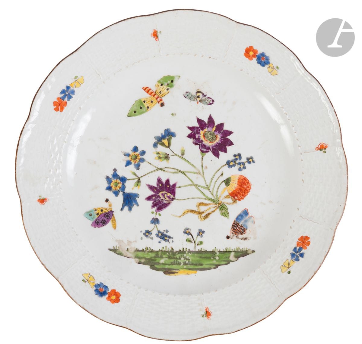 Meissen
Plate with contoured edge made of porcelain with wickerwork patterns on the wing with polychrome decoration in the Kakiemon style of knotted flowers, terrace and butterflies.
Marked: crossed swords in blue.
18th century, circa 1740.
D : 24 cm
Wear and tear.