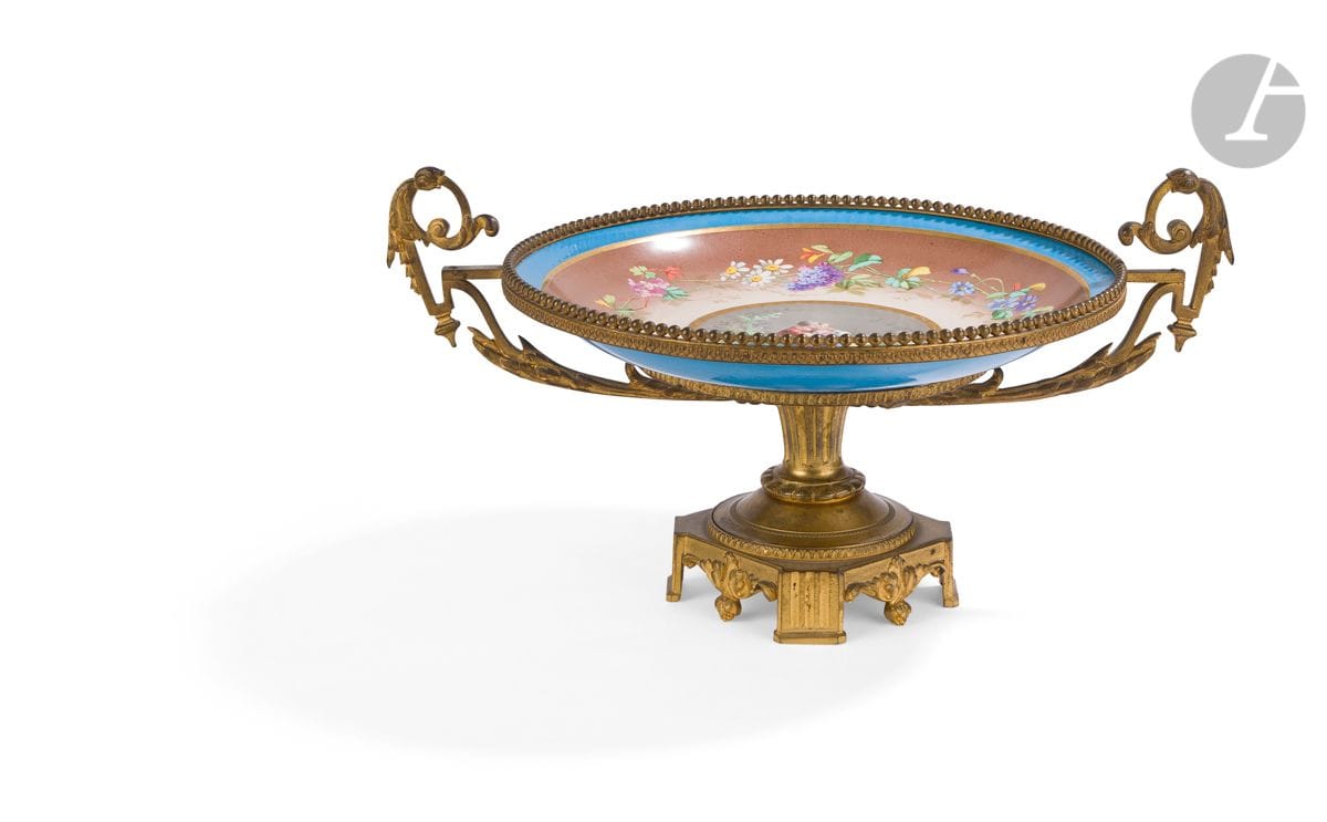 Coupe en porcelaine de Sèvres à décor d’une scène galante à monture de bronze doré à feuillages et cannelures.
Style Louis XVI, fin du XIXe siècle.
H : 22 cm, L : 41 cm
