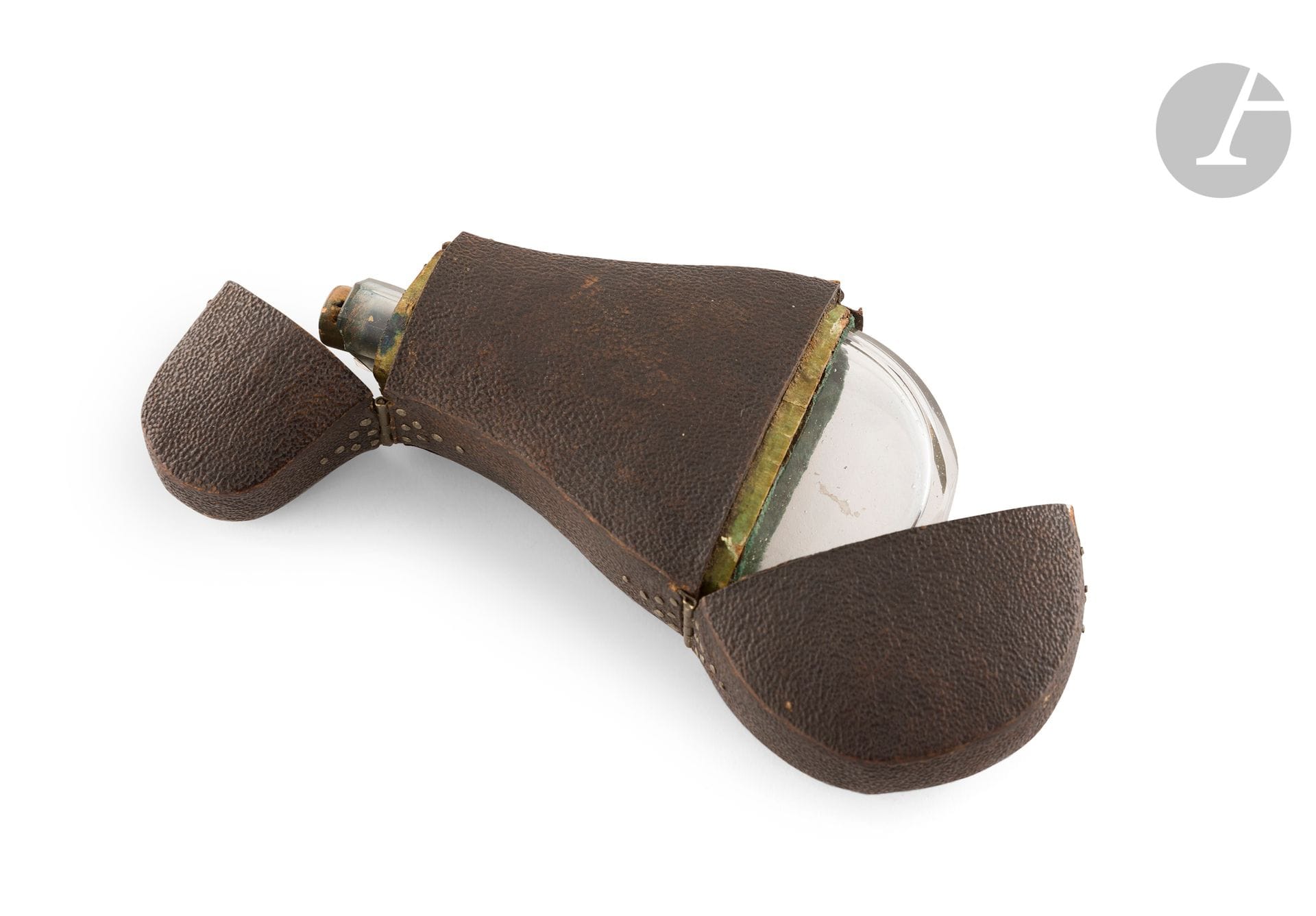 FRANCE FIN DU XVIIIe SIÈCLE - DÉBUT DU XIXe SIÈCLE
Encrier en verre de voyage piriforme dans son écrin en galuchat noir à clous d’argent ouvrant à bouton poussoir et charnière.
Longueur : 12,8 cm
État : éclat à l’extrémité de l’encrier.