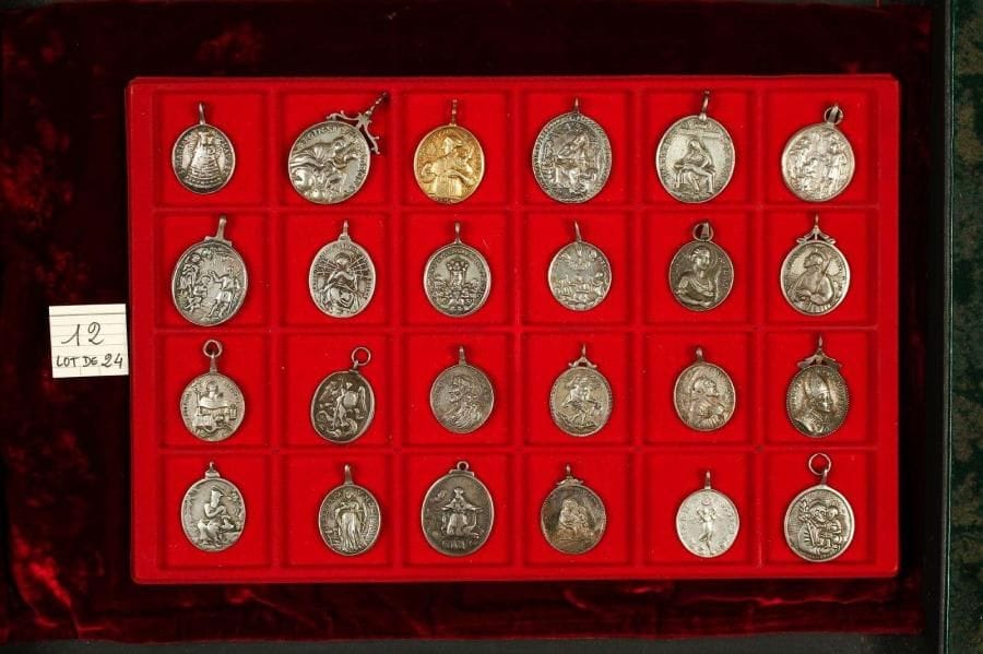 LOT de 24 médailles ovales (35 à 27mm) à bélière dont 1 en vermeil et 14 en argent: Christ, Vierge Marie, saints(es) Raymond, Lucie, Michel, François, Eloi, Barbe, scènes religieuses … TTB et TB