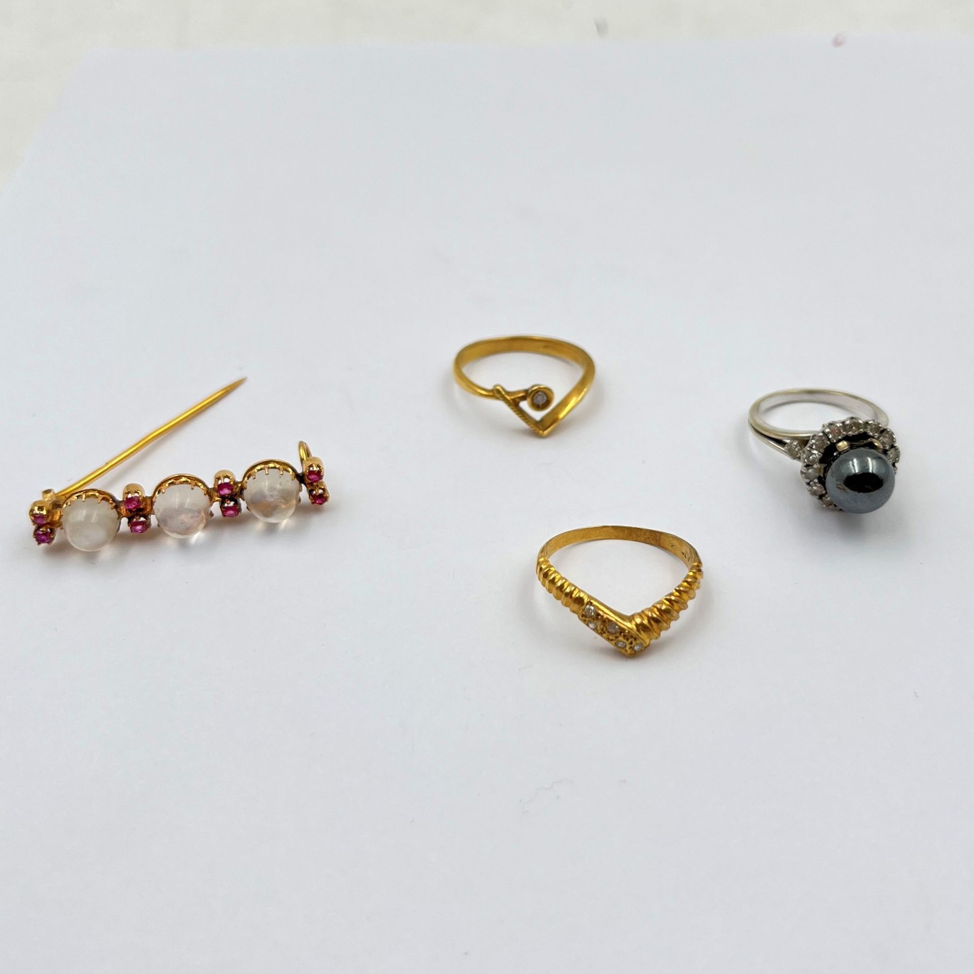 Lot de bijoux en or (18K). Poids brut : 14,2 g

- 1 bague en or gris (18K) et perle grise (T:49). Poids brut: 5,9 g

- 2 bagues en or (18K) et pierre blanche (T: 53) et 1 broche cabochons blancs et pierres rouges. Poids brut: 8,3 g

Frais acheteur pièces et lots en or : 9,6% TTC -  8% HT 