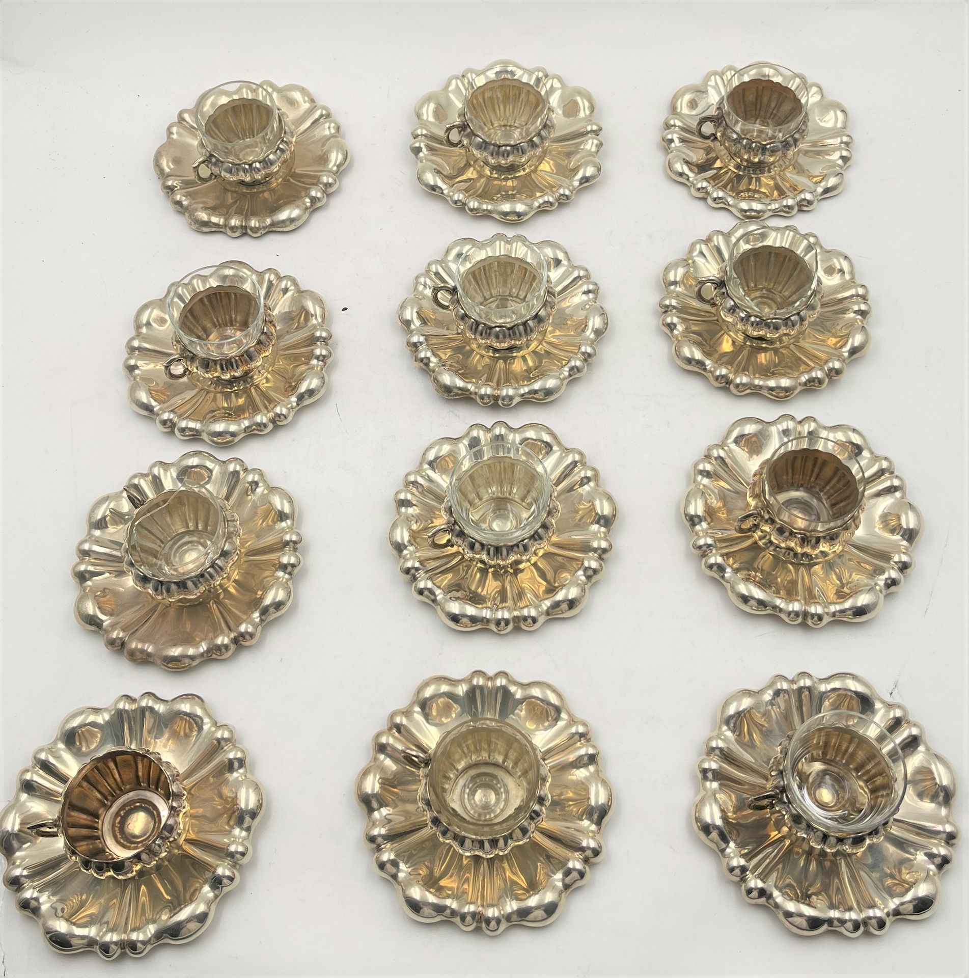 AUTRICHE-HONGRIE 1866-1922 

 Lot de 12 tasses à café et sous-tasses en argent 800/°°° à décor repoussé de côtes. 

 On y joint 11 verres dont 2 cassés.

 Poids net : 1974 g