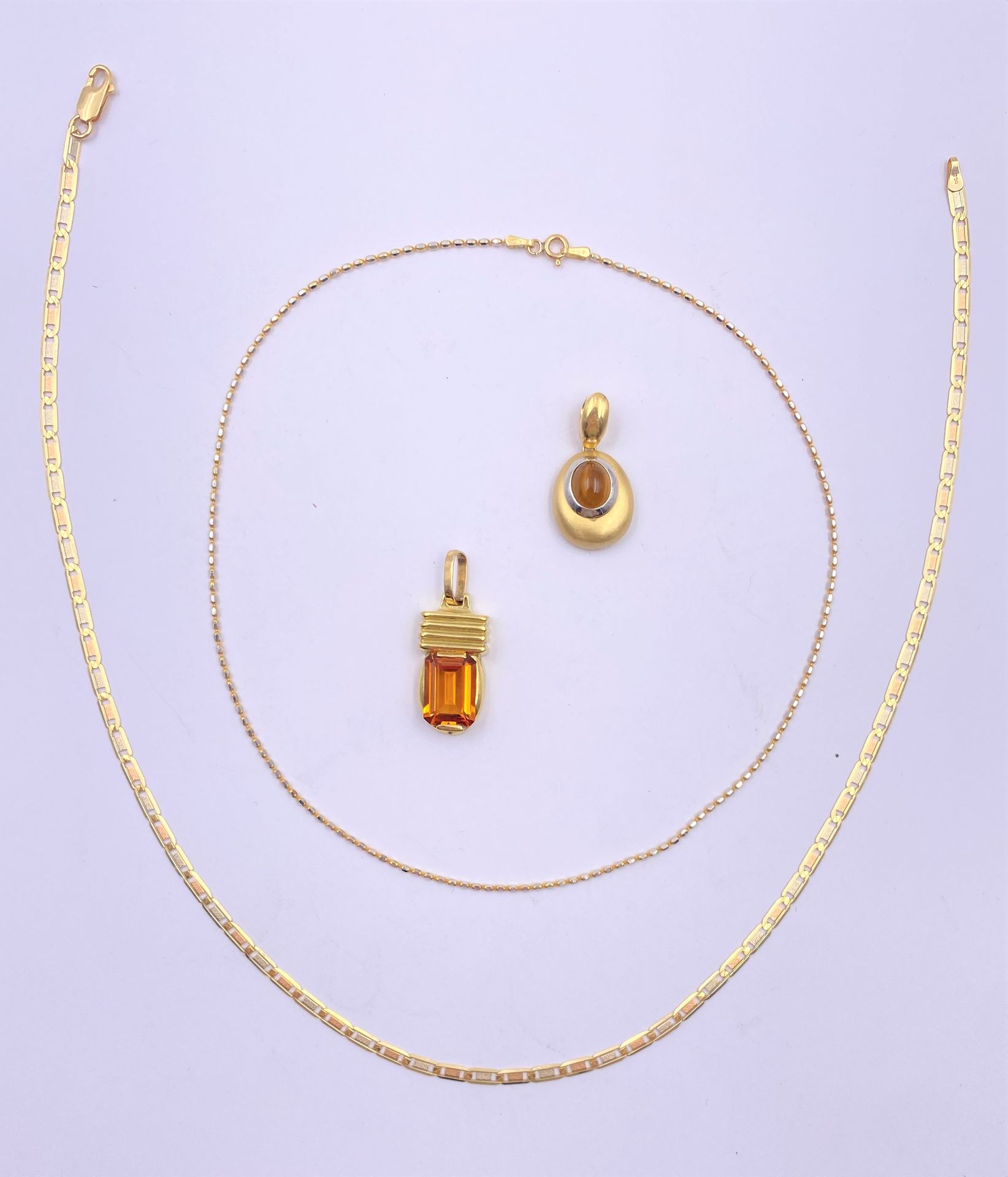 Lot de bijoux en or (18K). Poids brut: 24,1 g

- 2 chaines en or (18K)(19 et 22 cm). Poids : 12,8 g

- 2 pendentifs avec pierres (citrines ?). Poids brut: 11,3 g

Frais acheteur pièces et lots en or : 9,6% TTC -  8% HT 