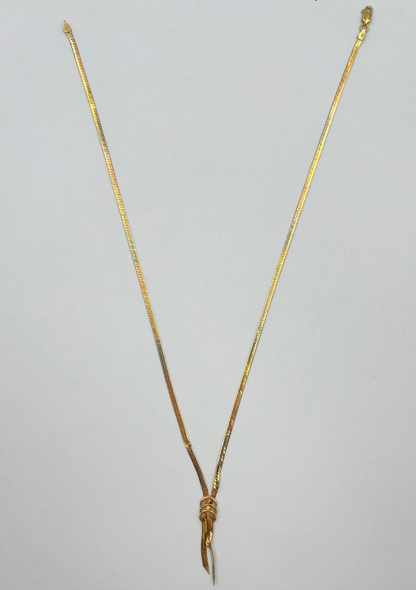 Un collier négligé ruban en or (18K). Poids: 8,3 g

Frais acheteur pièces et lots en or : 9,6% TTC -  8% HT 