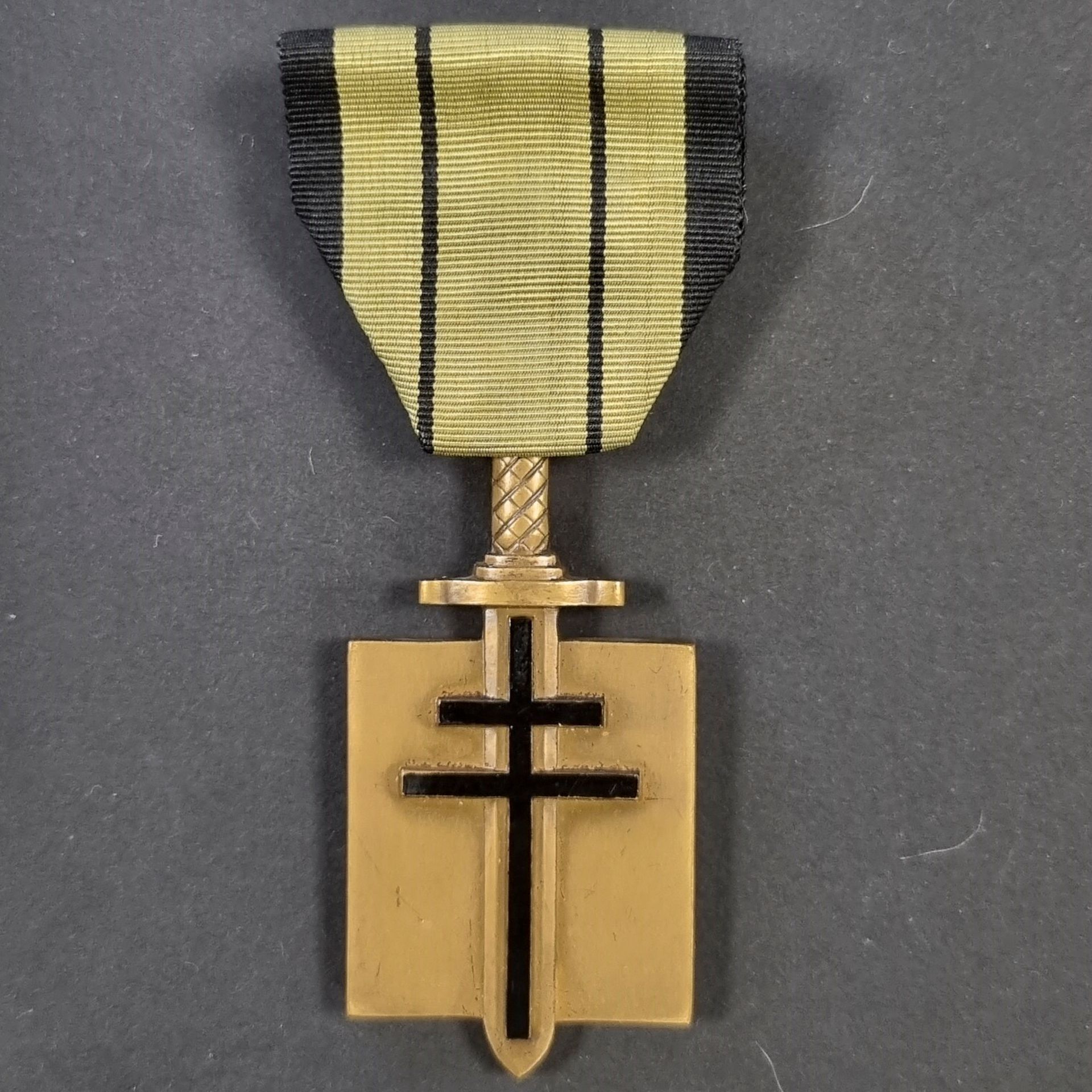 FRANCE 
ORDRE DE LA LIBÉRATION (1940).
Croix de compagnon, modèle à poignée du glaive strié sur deux faces.
Fabrication en bronze, à croix de Lorraine et légende du revers émaillés. 
Ruban du 2e type. Poinçon de la Monnaie 
« corne BR ».
57 x 30 mm 
T.T.B.