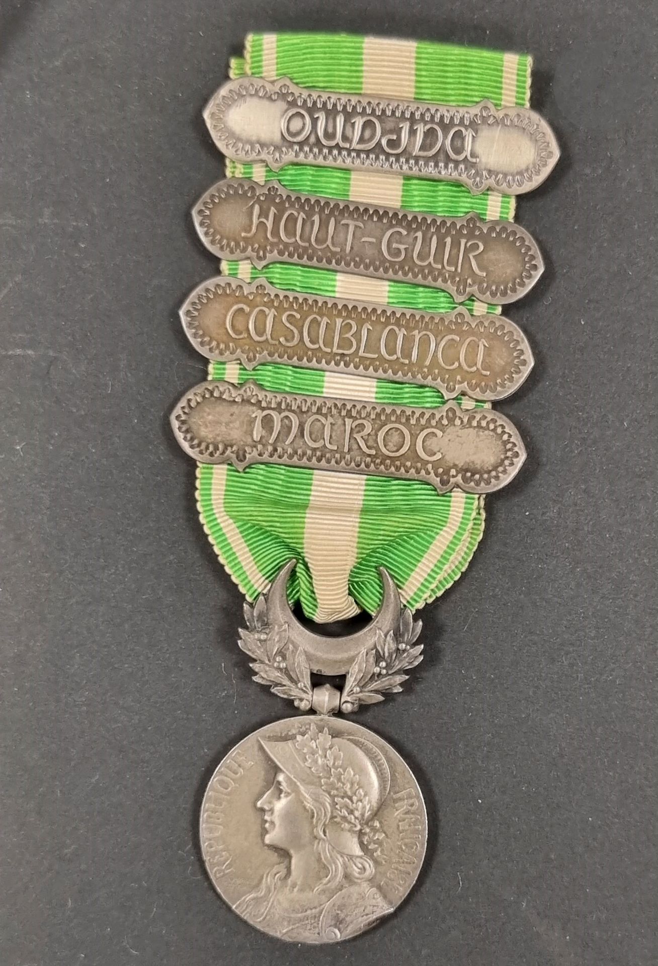 FRANCE 
MÉDAILLE DU MAROC (1909)
Médaille par Lemaire. En argent, poinçon de la Monnaie. Ruban à agrafe « MAROC », « HAUT GUIR », « CASABLANCA » et « OUDJDA ». 
48 x 28 mm - Poids brut : 21 g 
T.T.B.