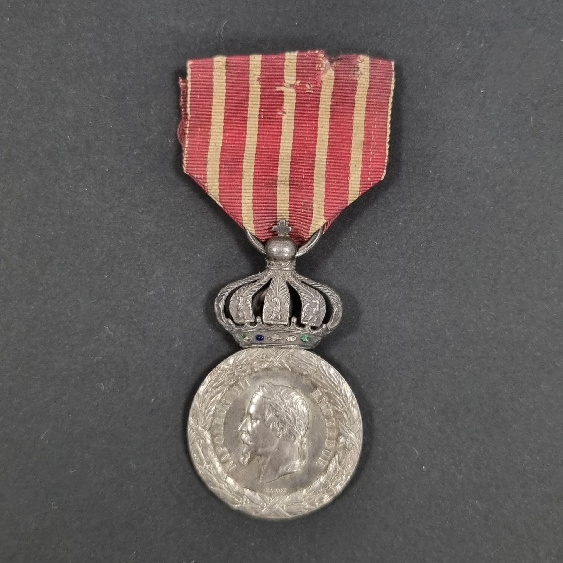 FRANCE 
Médaille de la Campagne d’Italie du 2e type, modèle sous couronne, par BARRE. 
En argent. Poinçon rectangulaire à tête d’aigle sur la bélière. Ruban court usé. 
50 x 29 mm - Poids net : 17 g 
T.T.B.
