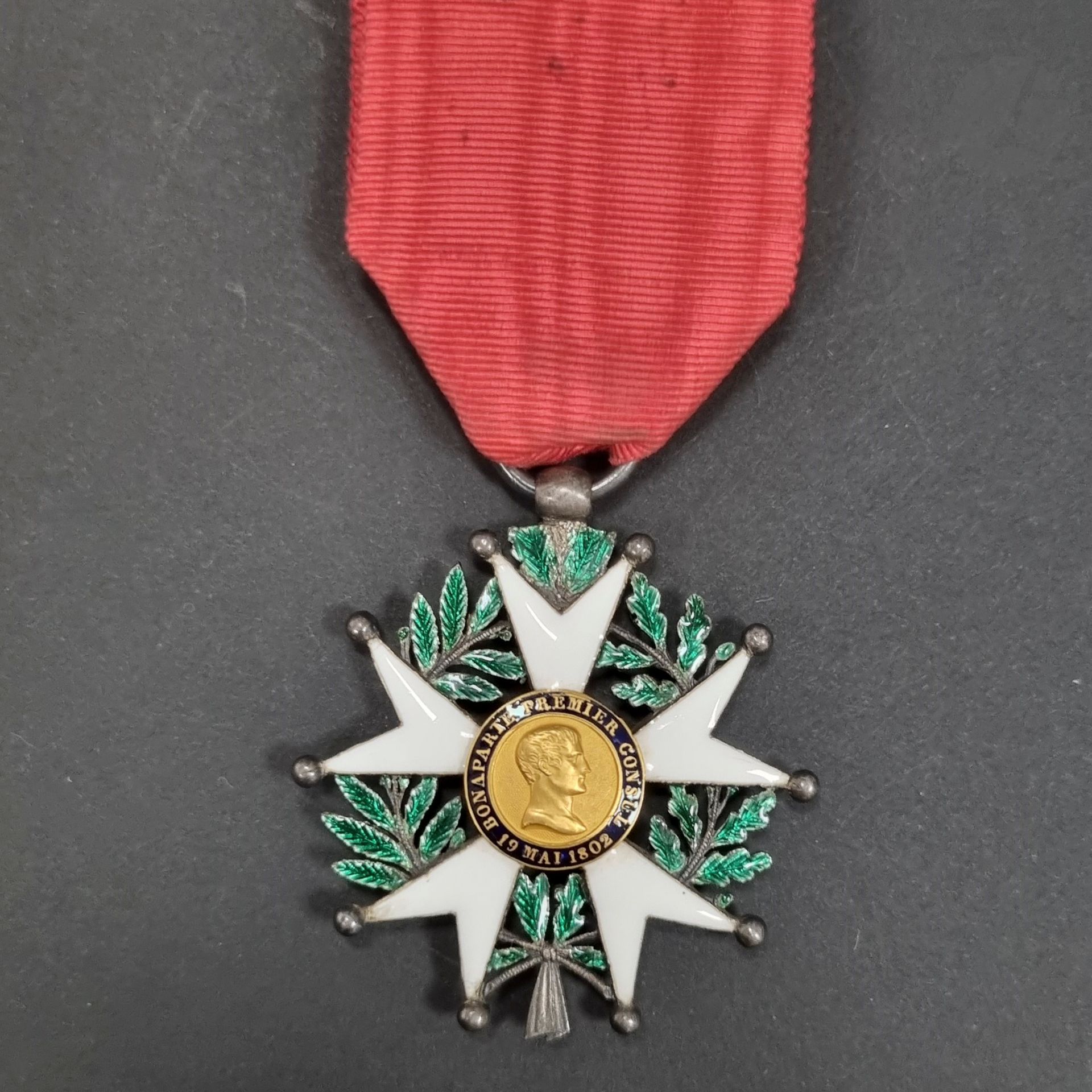 FRANCE 
ORDRE DE LA LÉGION D’HONNEUR (1802) 
Étoile de chevalier d’époque IIe République. 
En argent et émail (petits éclats), centres en or émaillé, au profil du 1er consul « à grosse tête ». Bélière en olive, anneau lisse. Ruban. Poinçon tête de sanglier. 
45 mm - Poids brut : 20 g
T.B.