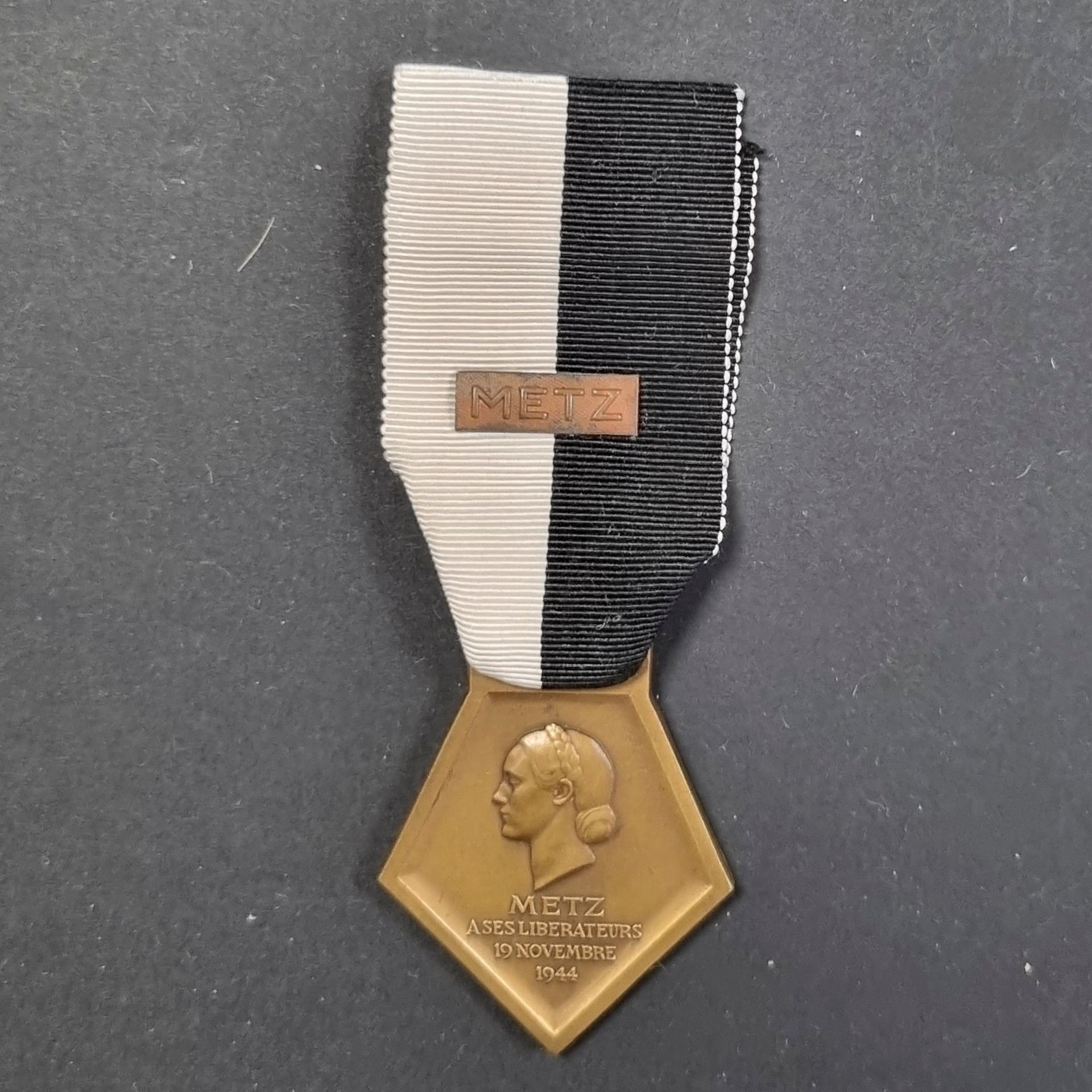 FRANCE 
MÉDAILLE DE LA LIBÉRATION DE METZ (1944). 
En bronze, non poinçonnée. Ruban à petite agrafe 
« METZ ». 
42 x 37 mm
T.T.B.