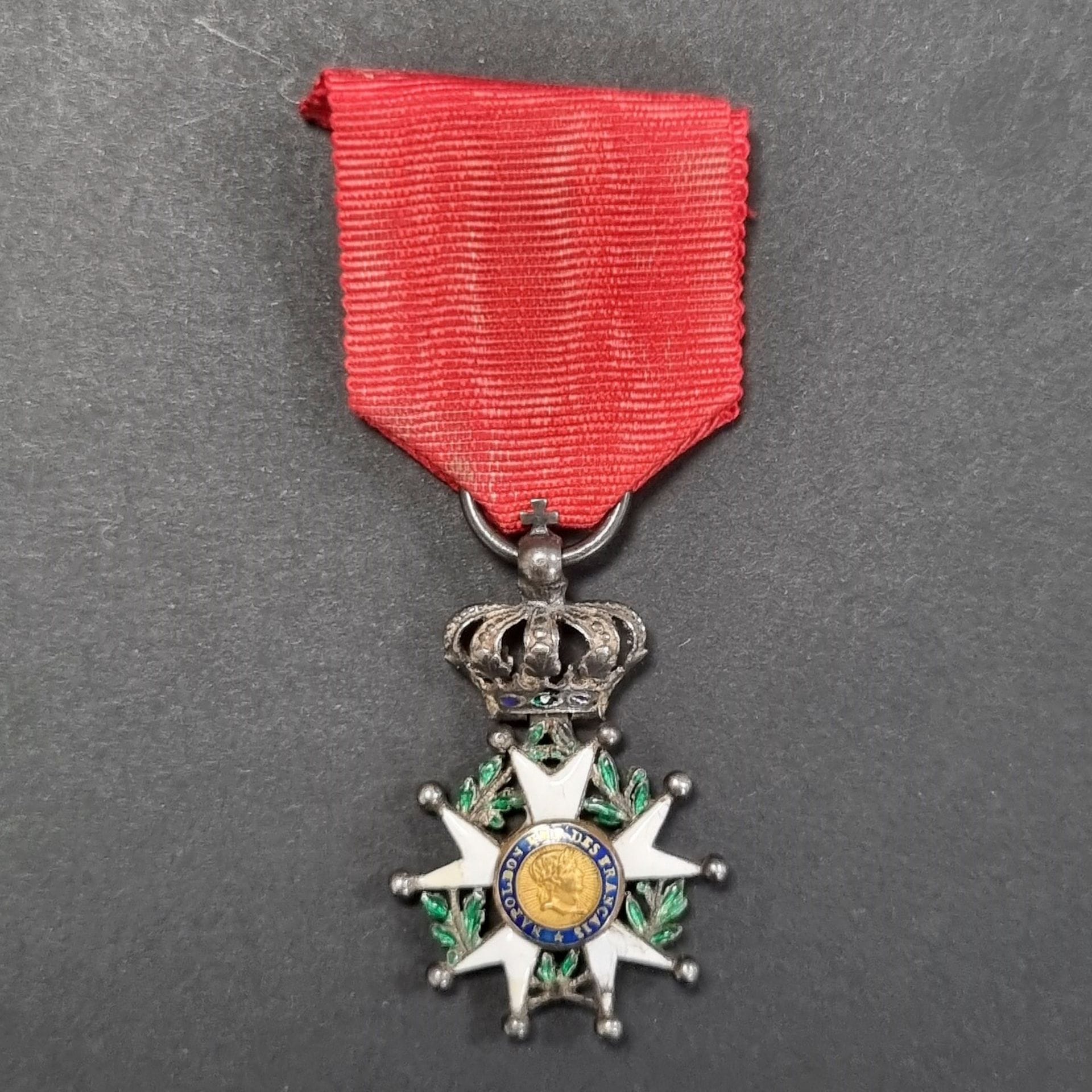 FRANCE 
ORDRE DE LA LEGION D’HONNEUR (1802).
Aigle d’argent du 4e type, à couronne montée à charnière, en réduction. 
En argent, or et émail (petits éclats). Couronne à décor de palmettes perlées. Étoile à branches boulées. 
Ruban postérieur. 
36 x 23 mm - Poids brut : 6 g 
T.B. à T.T.B.