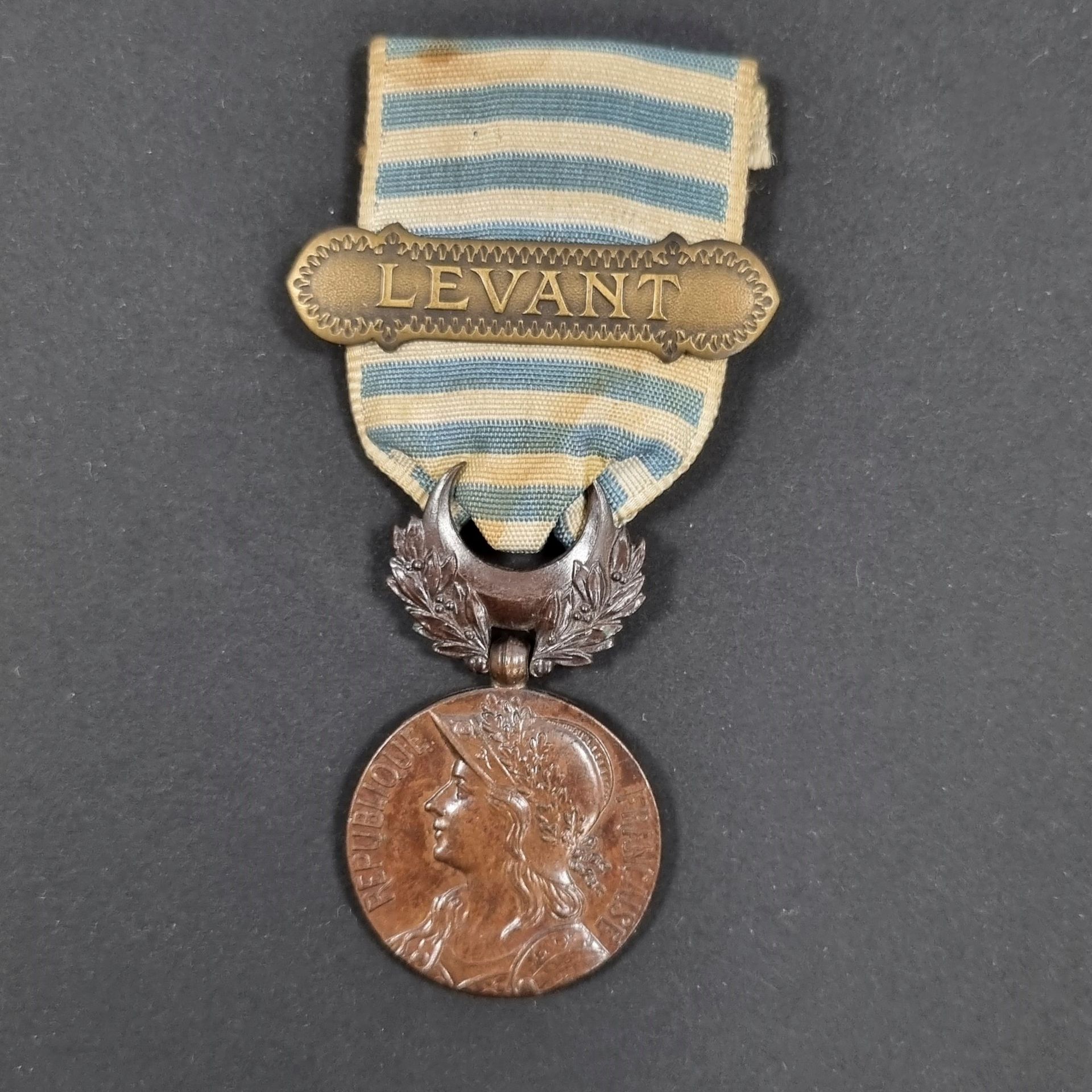 FRANCE 
MÉDAILLE DU LEVANT
Médaille en bronze à patine dite « chocolat », signé J.R.G. (Maison Gaunt à Londres). 
Ruban (tâches) à agrafe de style oriental en bronze « LEVANT ».
Diamètre : 29 mm
T.T.B.