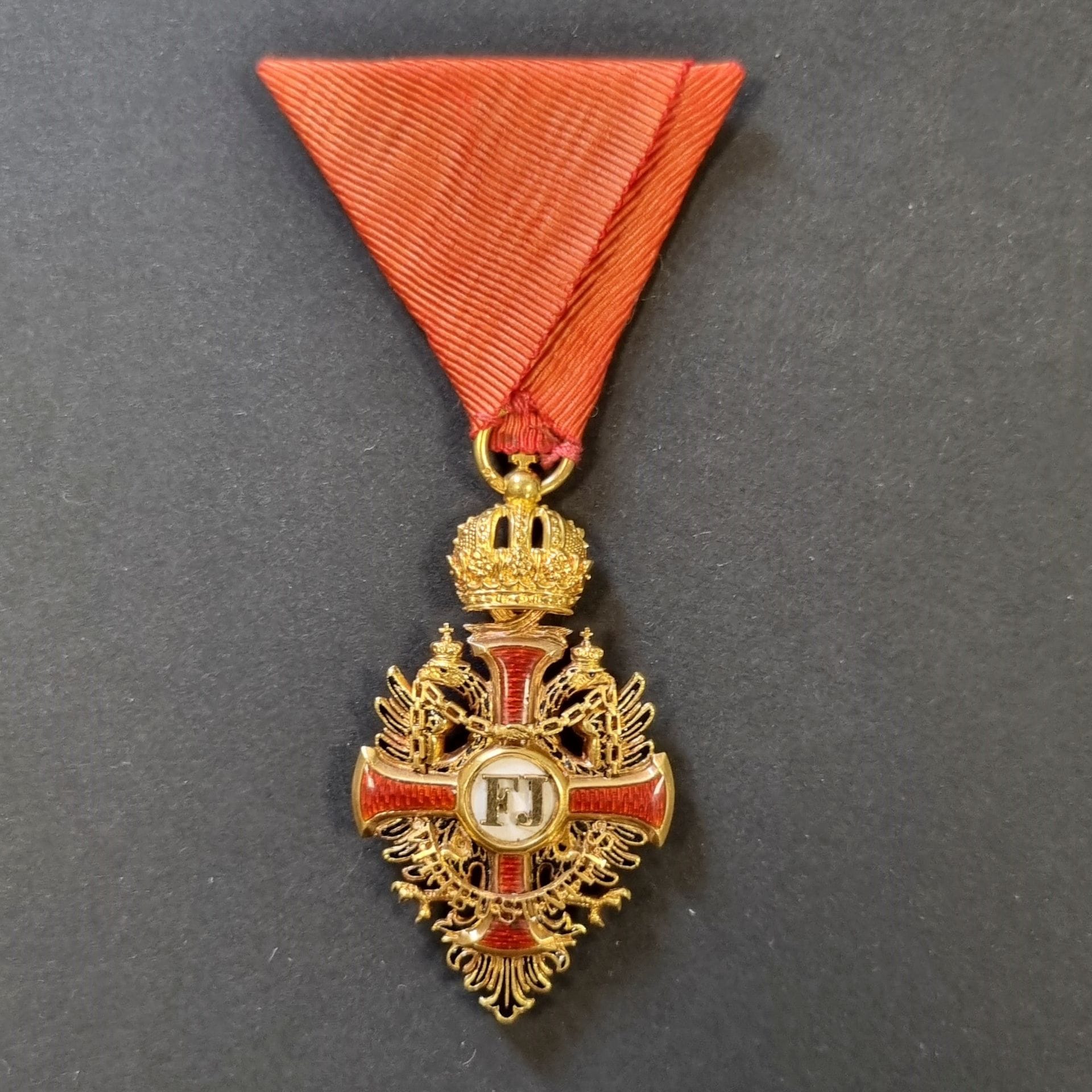 AUTRICHE 
ORDRE DE FRANCOIS JOSEPH (1849).
Étoile de chevalier. 
En or et émail, revers du centre ouvrant.
Poinçon de titre 750 autrichien. 
Ruban triangulaire à l’autrichienne.
53 x 30 mm - Poids brut : 11 g 
T.T.B. à SUP.