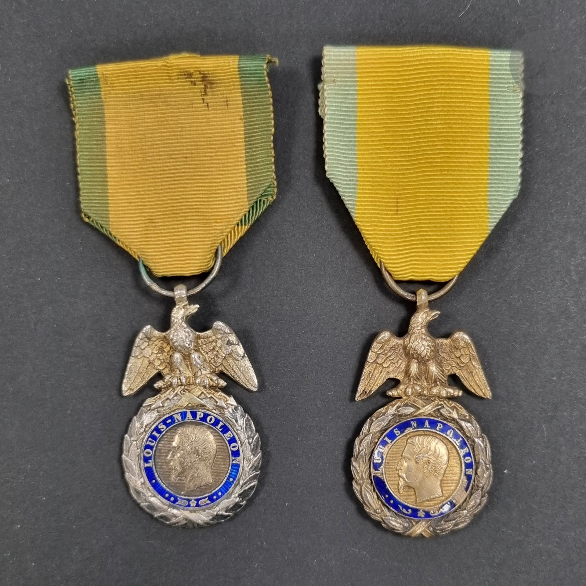FRANCE 
MÉDAILLE MILITAIRE
Deux médailles militaires du 2e type, deux fabrications différentes : 
En argent, vermeil et émail. Ruban. 
- poinçon tête de sanglier. Revers signé « BARRE » sur fond uni. 
- fabrication épaisse, aigle repris en ciselure, avers du centre bombé, poinçon tête de sanglier. Manques d’émail. Ruban postérieur. 
T.T.B. et T.B.