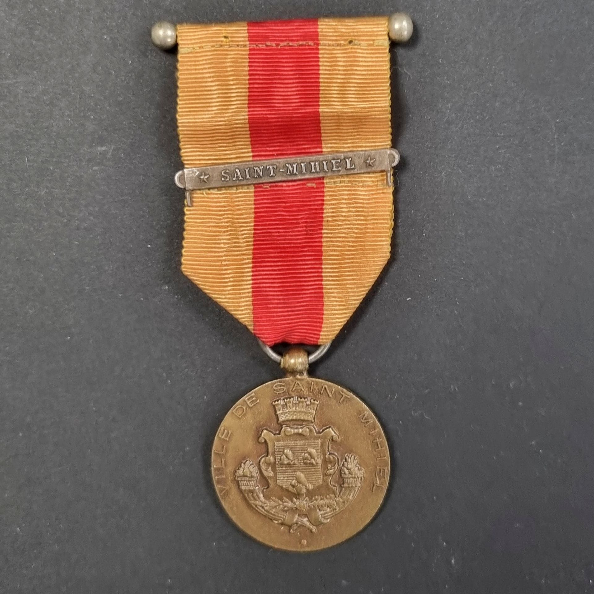 FRANCE 
Médaille commémorative de Saint Mihiel par DELANDE. 
En bronze. Bélière boule. Ruban cousu avec barrette US argenté « SAINT MIHIEL ».
33 mm
T.T.B