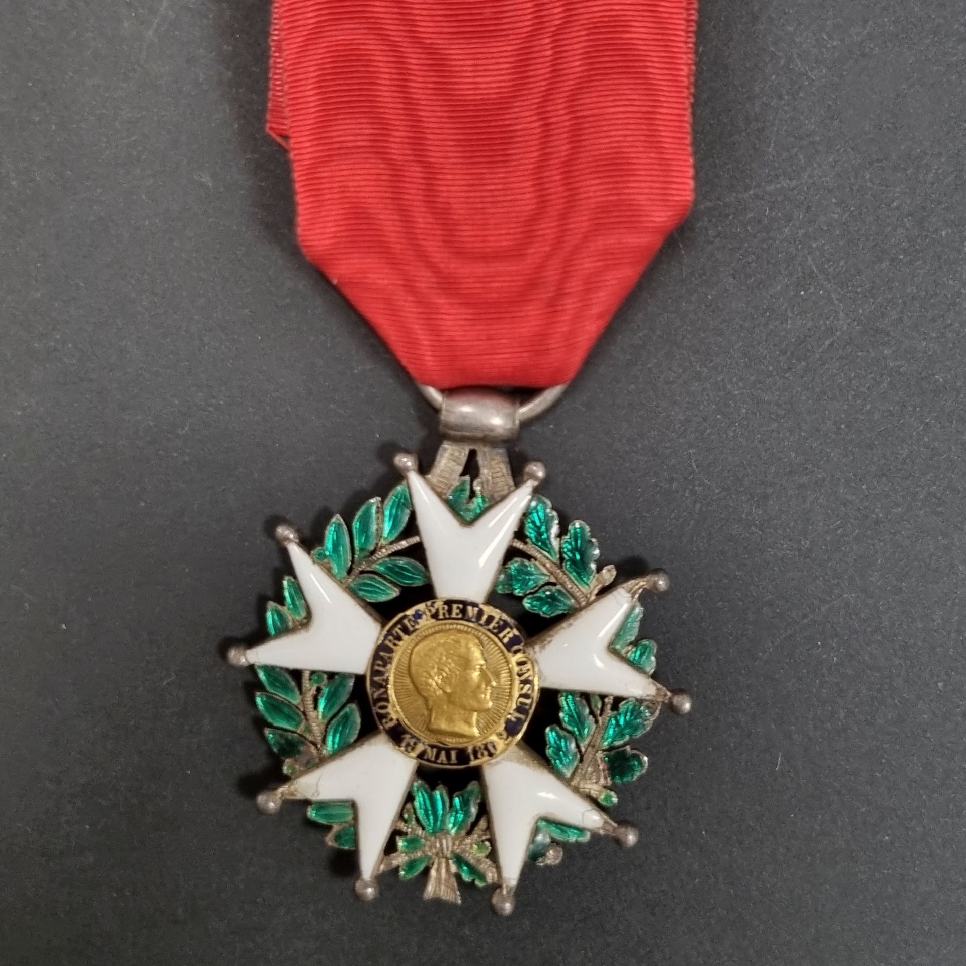 FRANCE 
ORDRE DE LA LÉGION D’HONNEUR (1802) 
Étoile de chevalier d’époque IIe République 
En argent et émail (éclats, trois boules faussées), centres en or, au profil du 1er consul « à grosse tête ». Bélière en large olive, anneau lisse. Ruban. 
44 mm - Poids brut : 17 g
B.