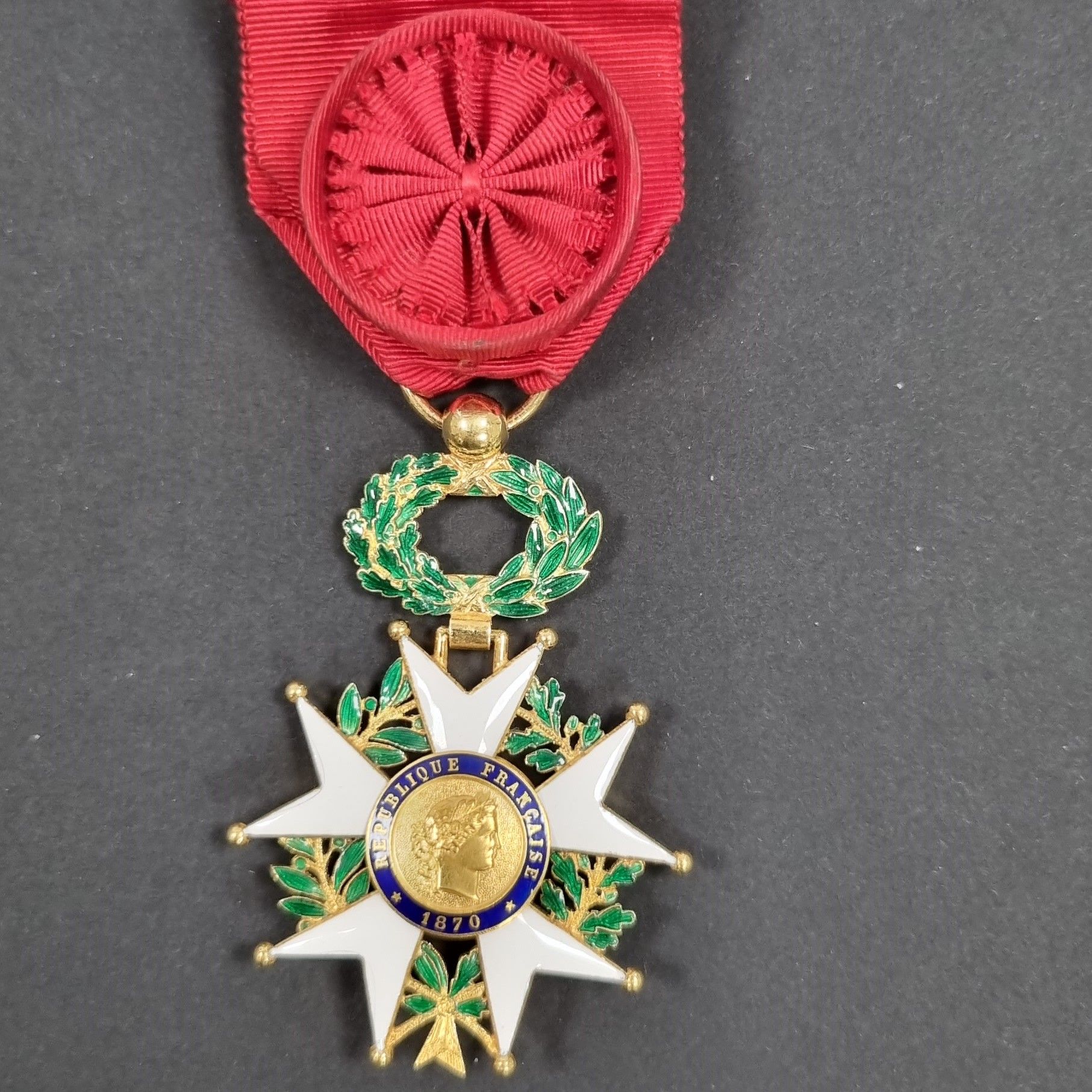 FRANCE 
ORDRE DE LA LÉGION D’HONNEUR (1802)
Étoile d’officier d’époque IIIe République. 
En or et émail (infime cheveu). Poinçon tête d’aigle et d’orfèvre Ouizille Lemoine. 
Ruban à rosette. 
60 x 41 mm - Poids brut : 23 g 
T.T.B.